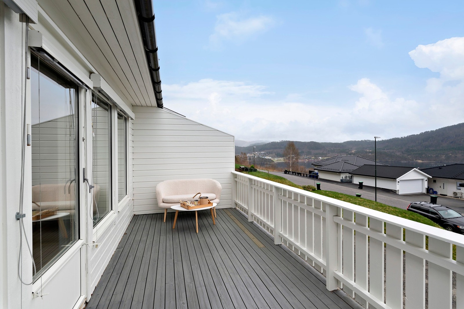 Fra stue har man utgang til sydvendt veranda. Legg merke til at det er utvendig persienne på vinduene og at du har plass til utemøbler her. Galleribilde