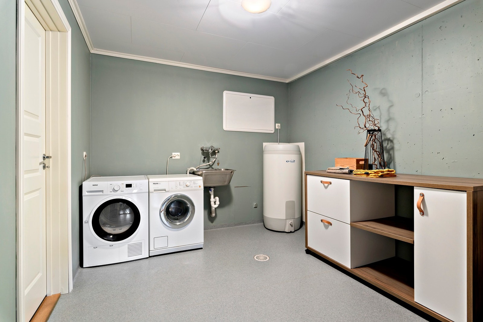 I underetasjen har du romslig og flott vaskerom. Gulvet har vinylbelegg, rørskap for rør-i rør opplegg, skyllekar i stål og selvsagt med sluk i gulvet. Galleribilde