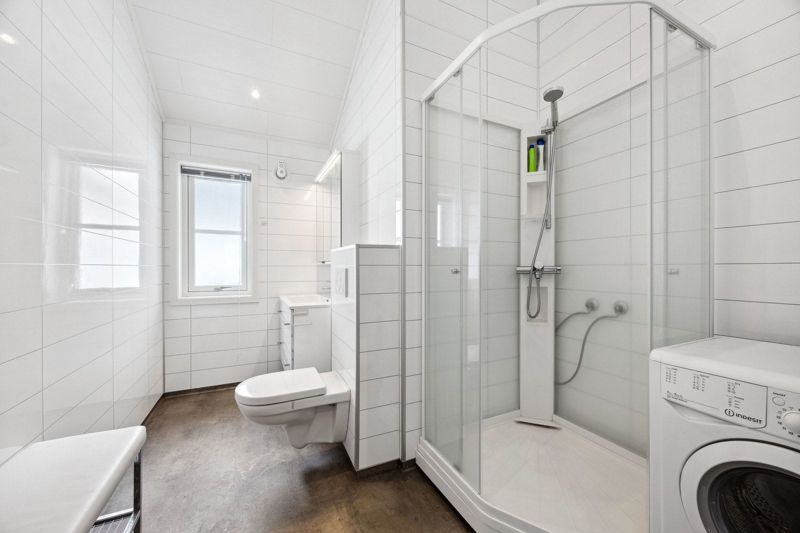 Pent baderom med våtromsplater på vegger og belegg på gulv Galleribilde