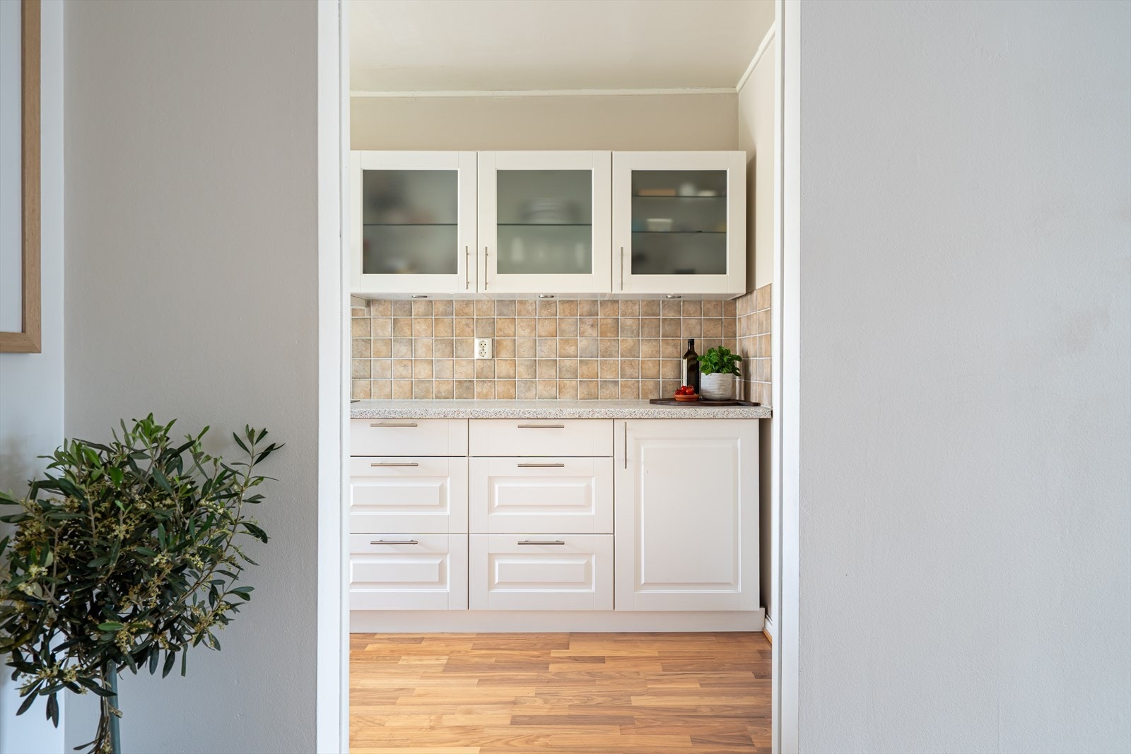 Leiligheten har et separat kjøkken med østvendt vindu og innredning plassert parallelt langs to sider. Galleribilde