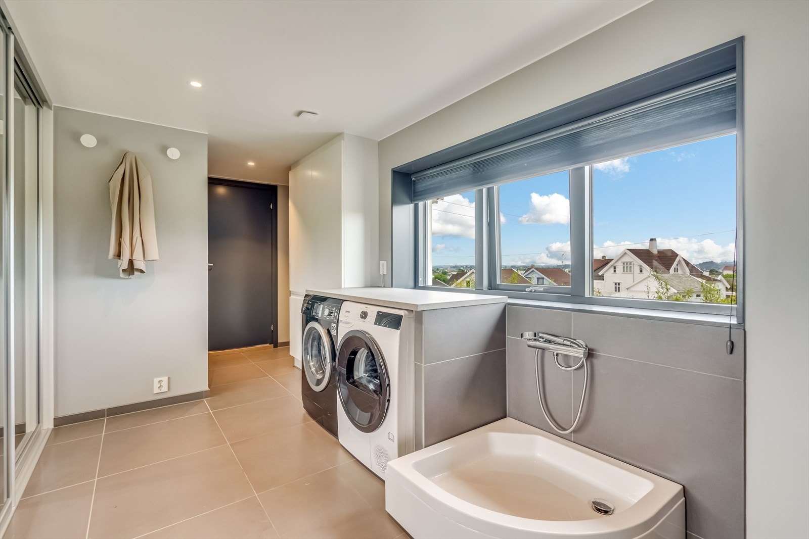 Vaskerom med bi-inngang, 60*60 fliser og dobbel plassbygget skyvedørsgarderobe med innredning. Galleribilde