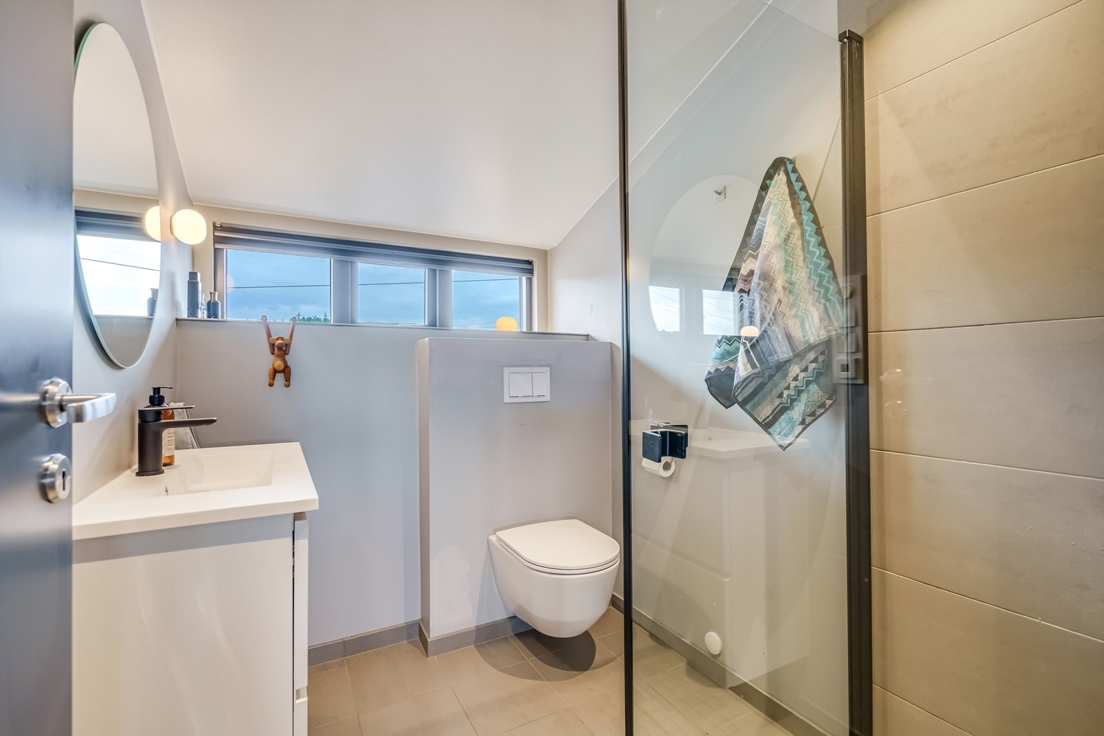 Bad på loft med dusjhjørne med glassdører Galleribilde