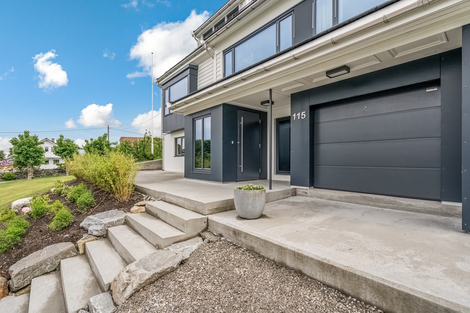 Utvendig stor bod med garasjeport med portåpner, innlagt belysning, støpt gulv og stikkontakter. Galleribilde