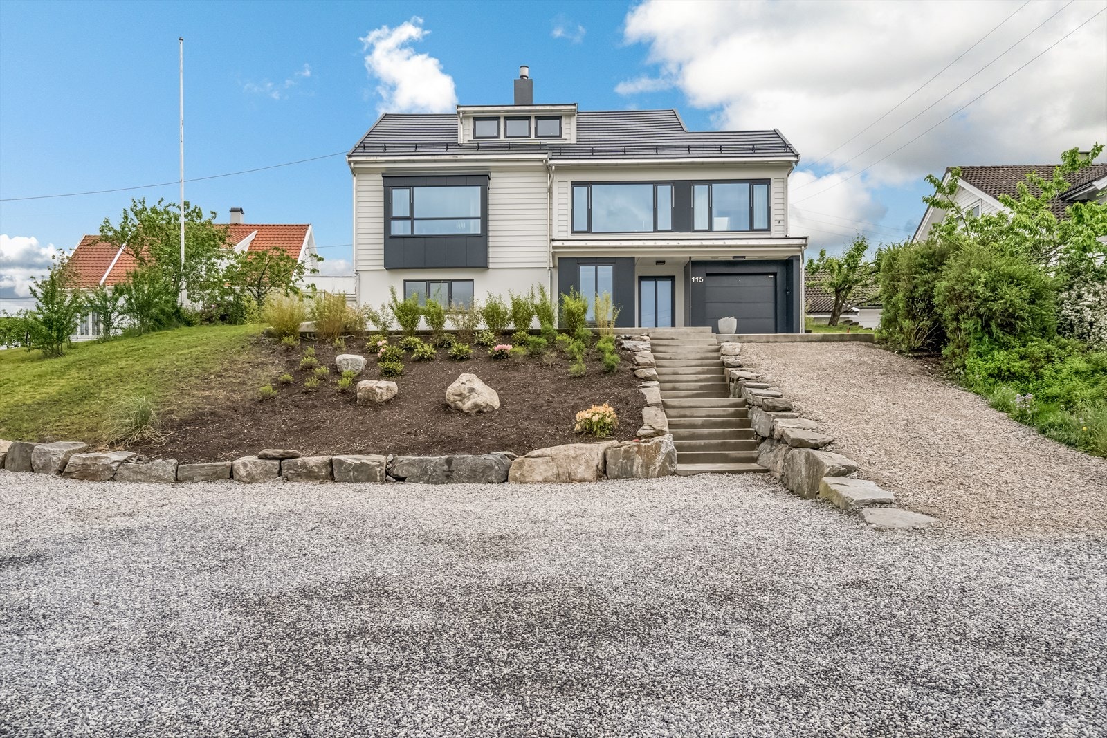Nyplantet og vedlikeholdsenkel skråning med vintergrønn beplantning som rhododendron. Galleribilde