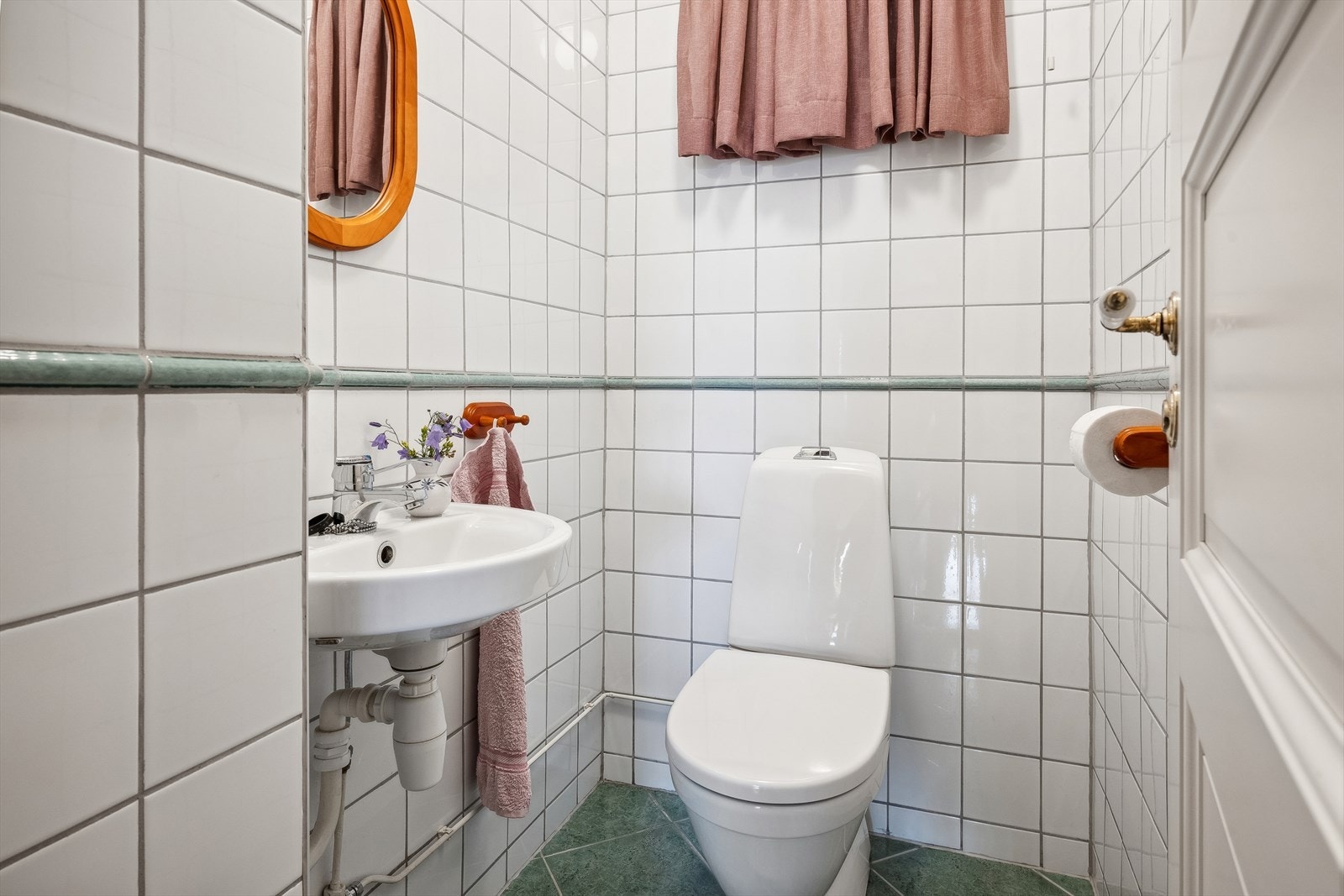 Vegg i vegg med badet er det separat toalettrom med flislagte overflater Galleribilde