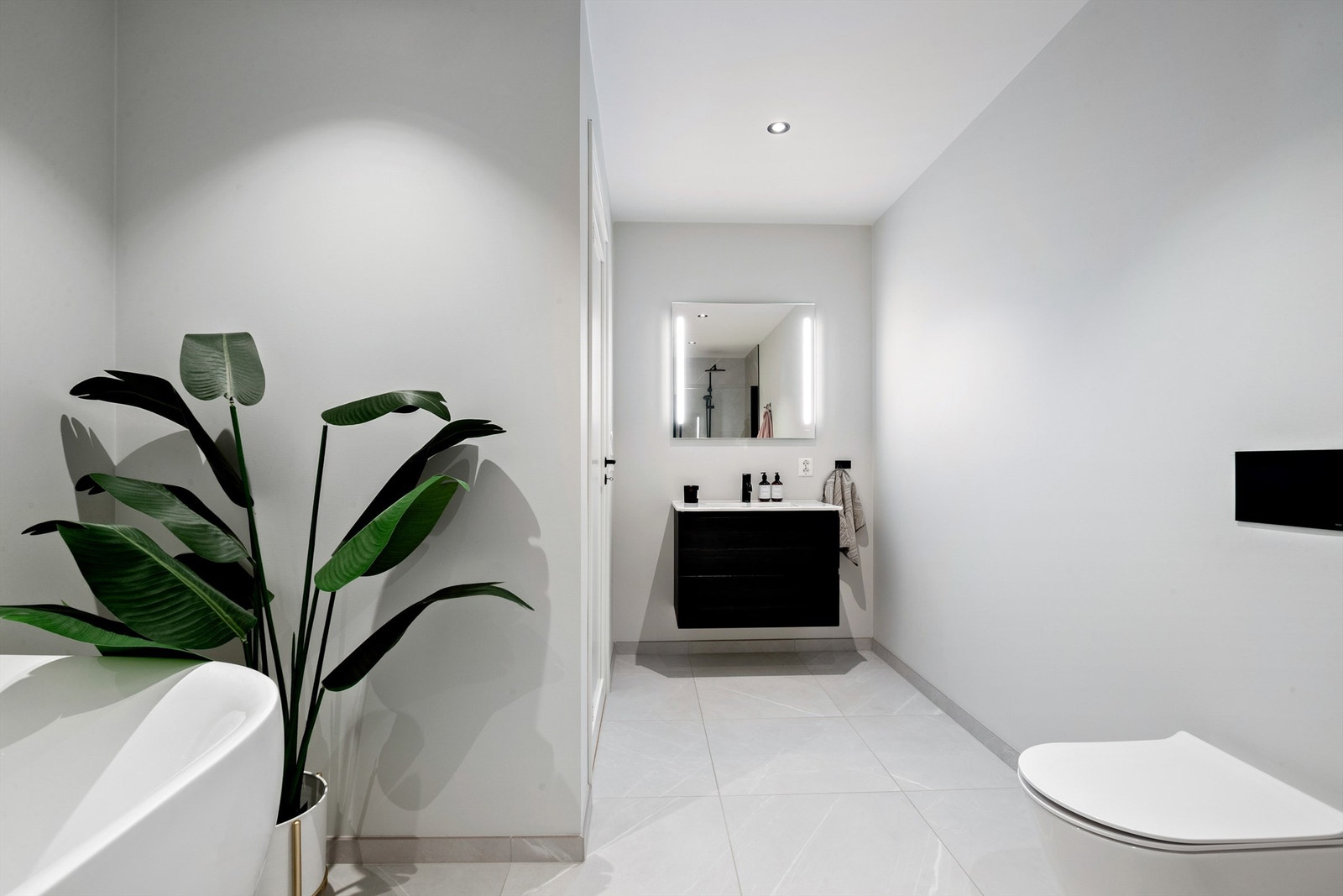 Delikat bad med varme i gulv og slett, lysmalt himling, med downlights Galleribilde