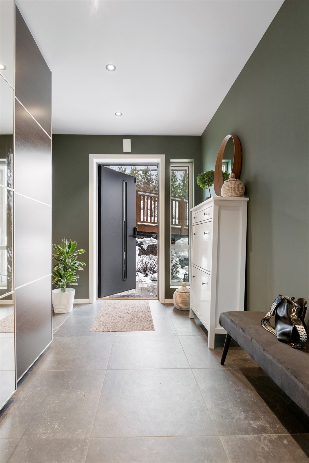 Velkommen inn i en flislagt entré med skyvedørsgarderobe Galleribilde