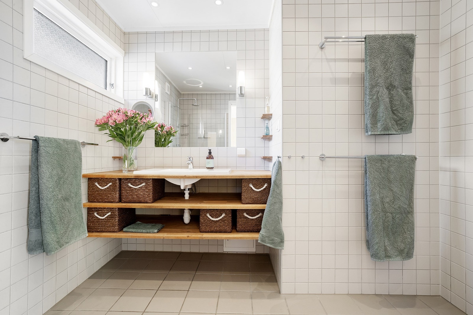 Badet er lyst og romslig, og har praktisk oppbevaring under servantinnredningen Galleribilde