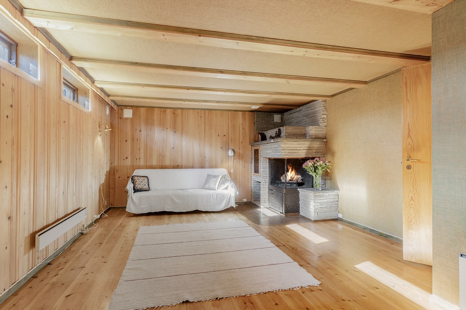 Rom benyttet som kjellerstue har en hyggelig peis i hjørne Galleribilde