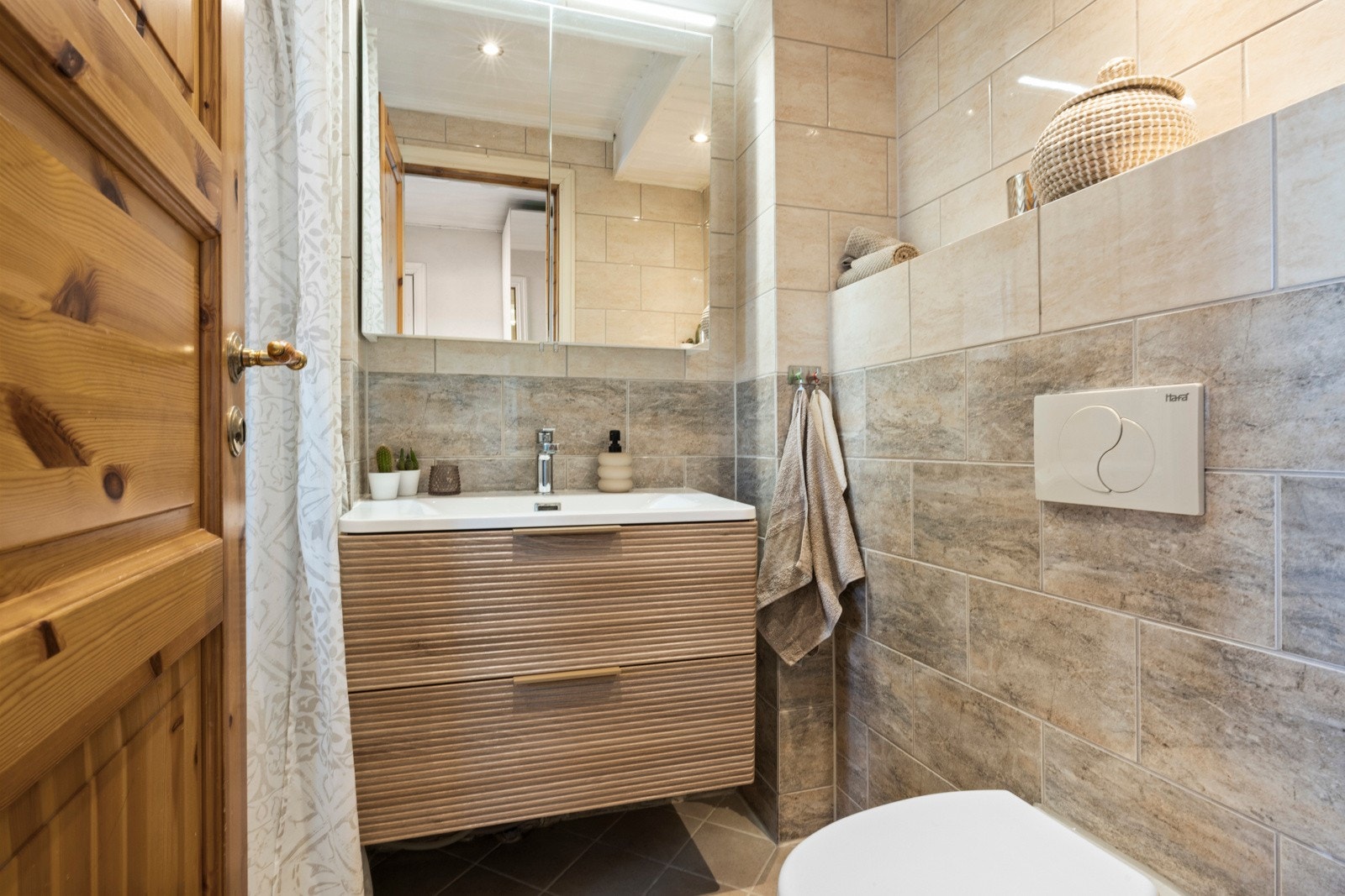 Badet i første etasje var oppusset i 2009 med fliser på veggene og downlights i taket Galleribilde