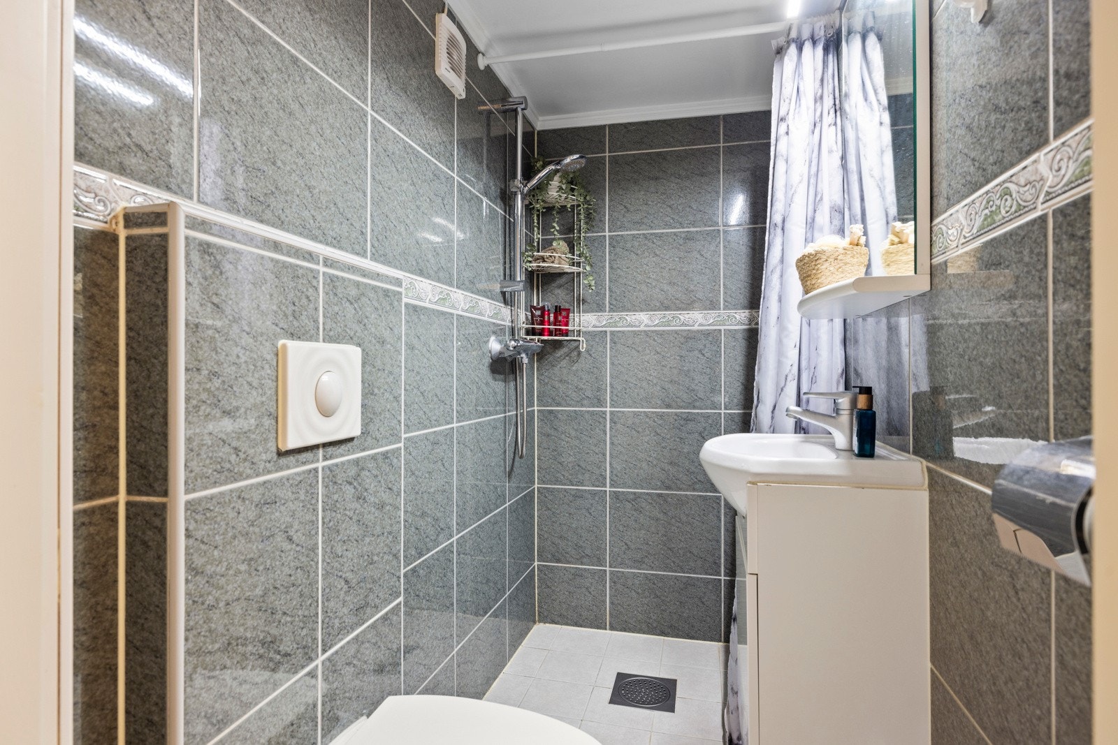 Badet i kjelleren er pusset opp i 2006, og har flislagte vegger og tak malt i en farge som gir rommet et rent og ryddig uttrykk Galleribilde