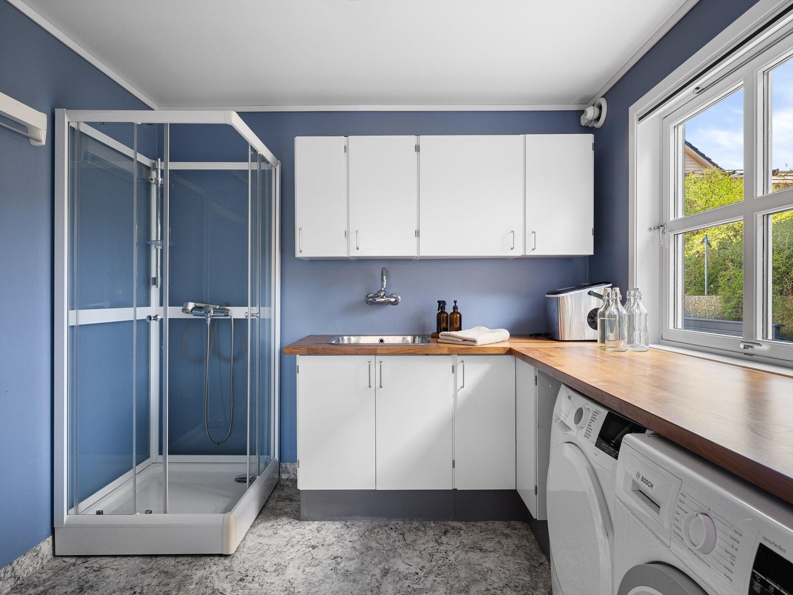 Ett av 3 baderom, her kombinert vaskerom med god arbeidsbenk og plass til tørking av klær. Vindu også her for naturlig lys. Galleribilde