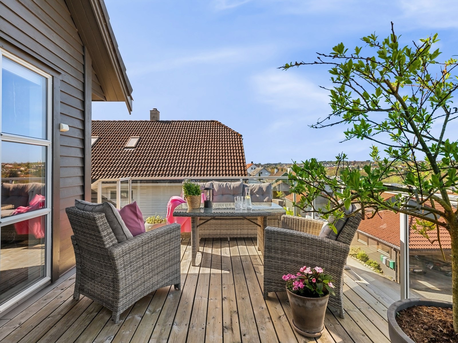 Romslig terrasse i front av boligen med glassrekkverk for maks utnyttelse av utsikten. Luftig, åpent og solrikt. Galleribilde