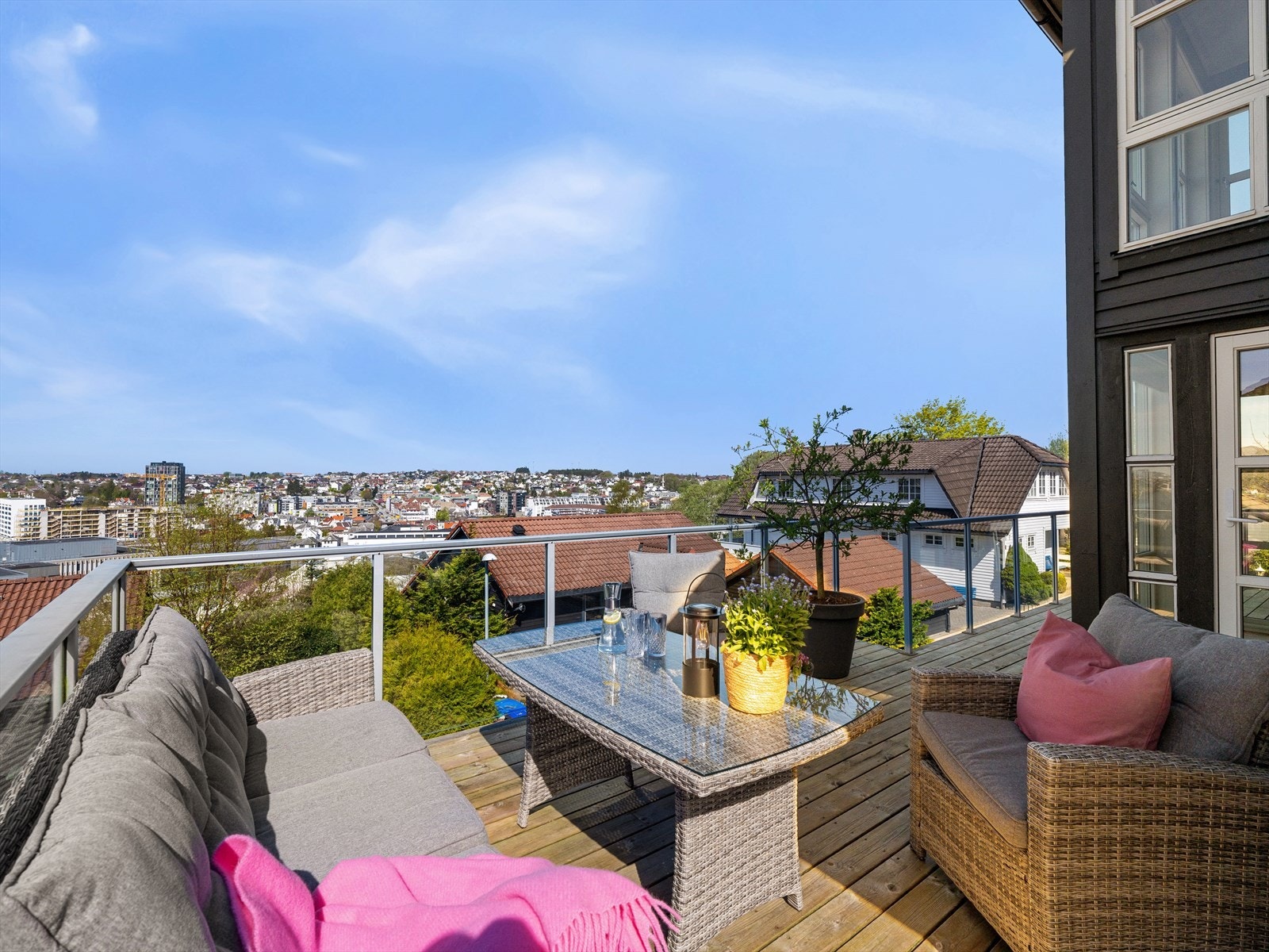 Romslig terrasse i front av boligen med glassrekkverk for maks utnyttelse av utsikten. Luftig, åpent og solrikt. Galleribilde