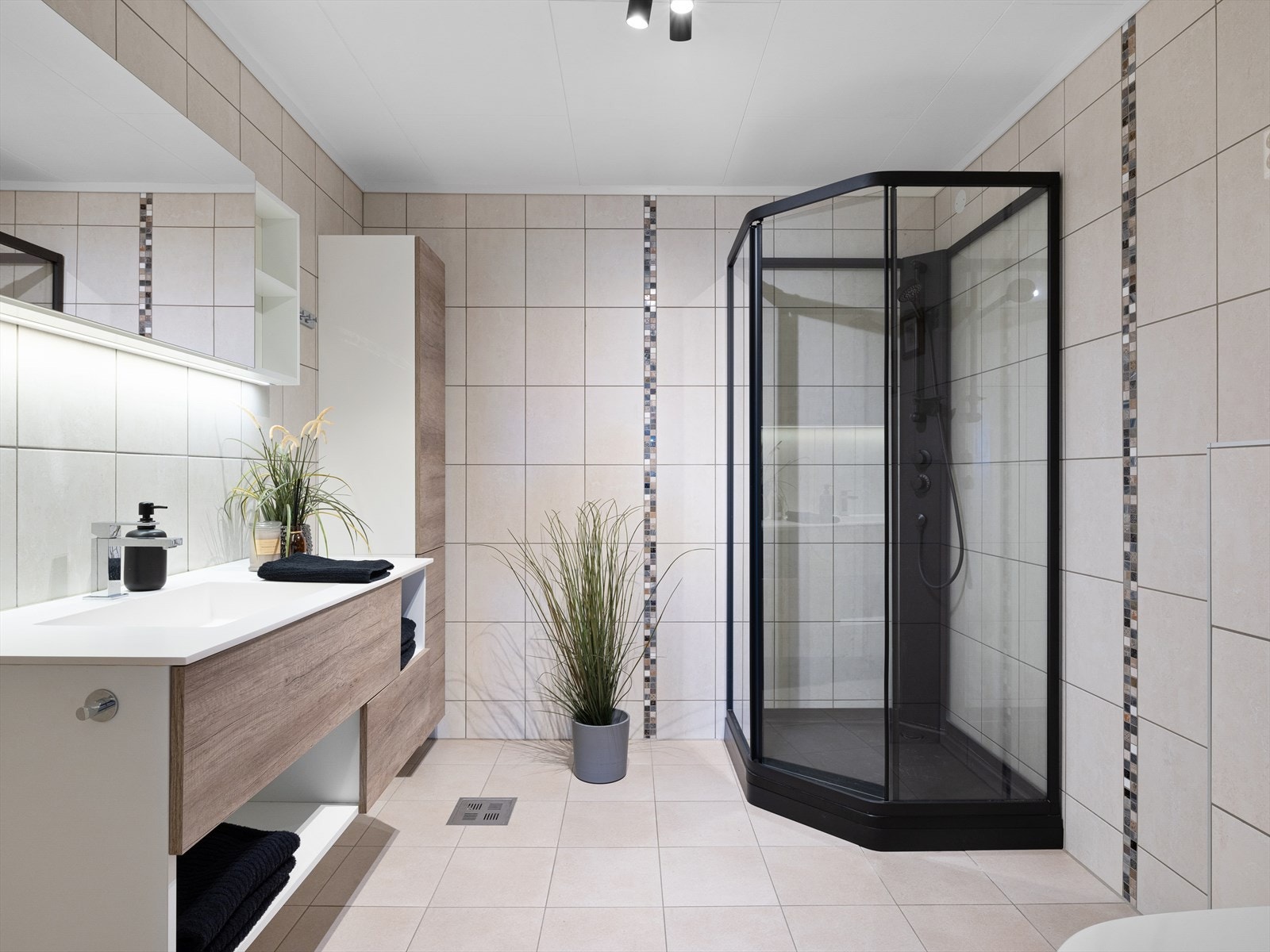 1 av 3 baderom. Helfliset og med varme i gulv. Delikat, moderne dusjkabinett og rikelig med oppbevaring i flere skap. Galleribilde