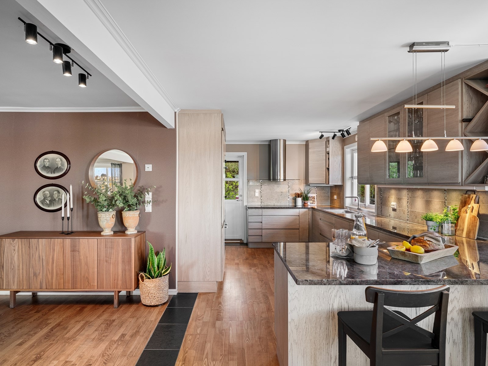 Huseby kjøkken med granittplate og rikelig med skapplass. Barløsning i enden for en kopp kaffe og PC. Direkte tilgang ut på solrike terrasser og til utestuen for sene kvelder med varmeovn. Galleribilde