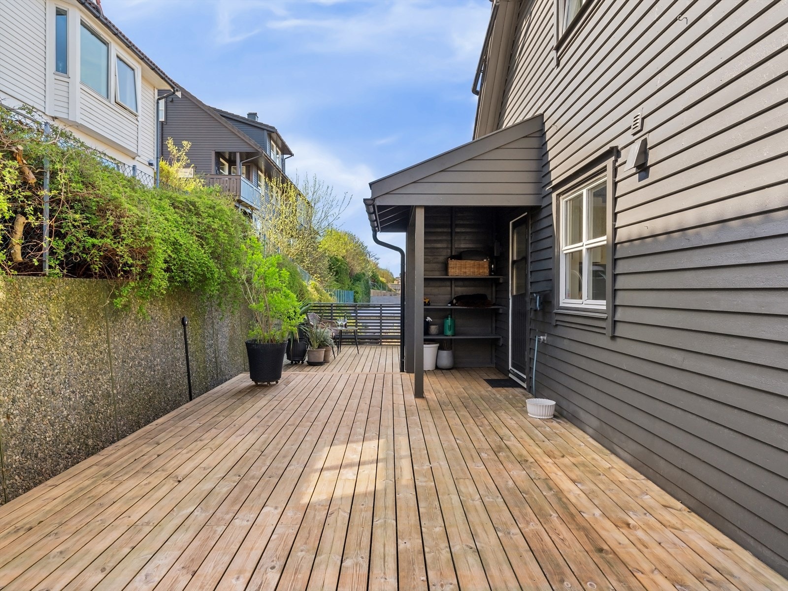 Takoverbygget bi-inngang med lagring i hyller. Store terrasser rundt boligen for ulike møbleringssoner og til enhver anledning. Galleribilde