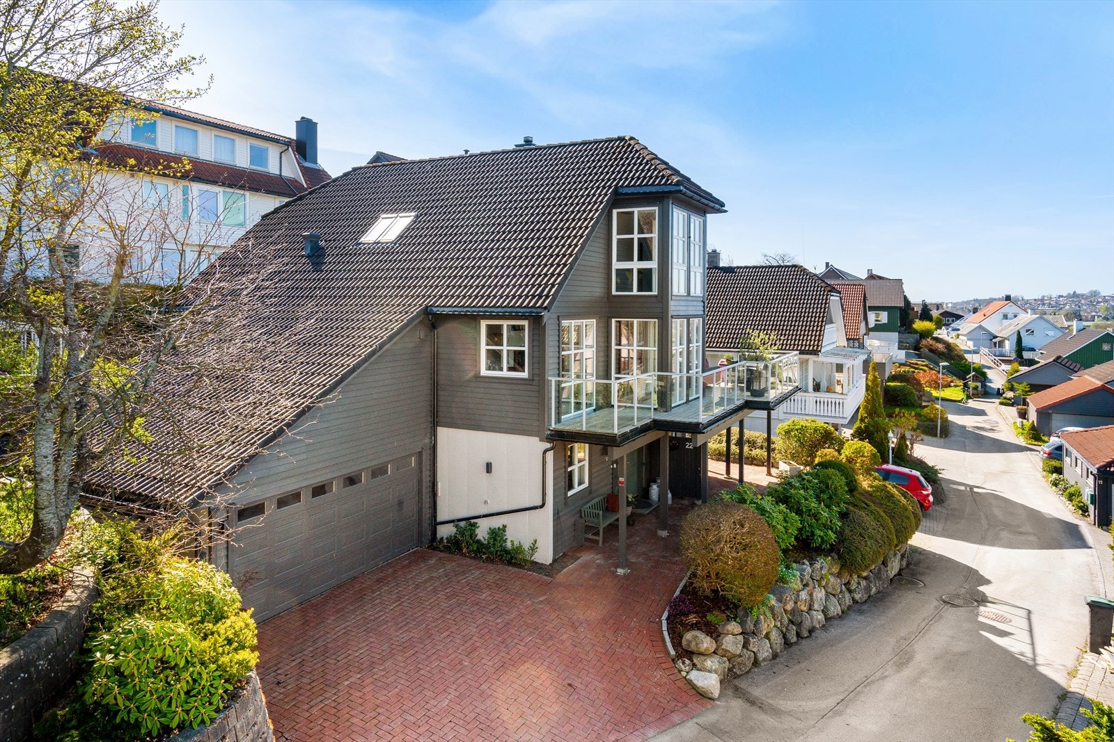 Dobbel garasje og plass til bil i gårdsrom. Terrasser rundt hele boligen og herlig utestue. Nydelig utsikt over byen, mot parken og mot fjorden. Strålende solforhold. Galleribilde