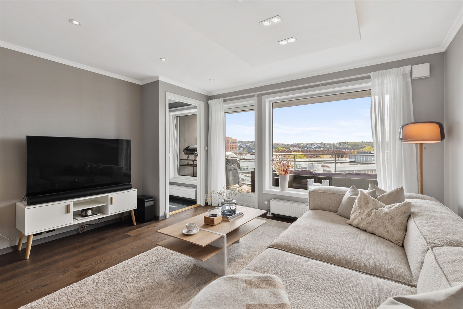 Det er rikelig med lysinnslipp fra store vindusflater som brer seg over hele den ene kortsiden i rommet. Galleribilde