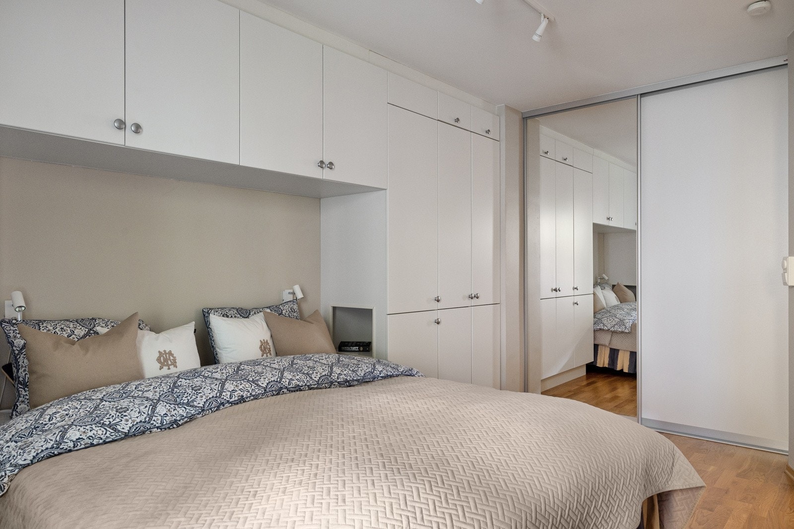 Soverommet er innredet med en stor skyvedørsgarderobe langs den ene veggen som gir praktisk oppbevaringsplass for klær og sengetøy, og bidrar til et ryddig og organisert rom. Galleribilde