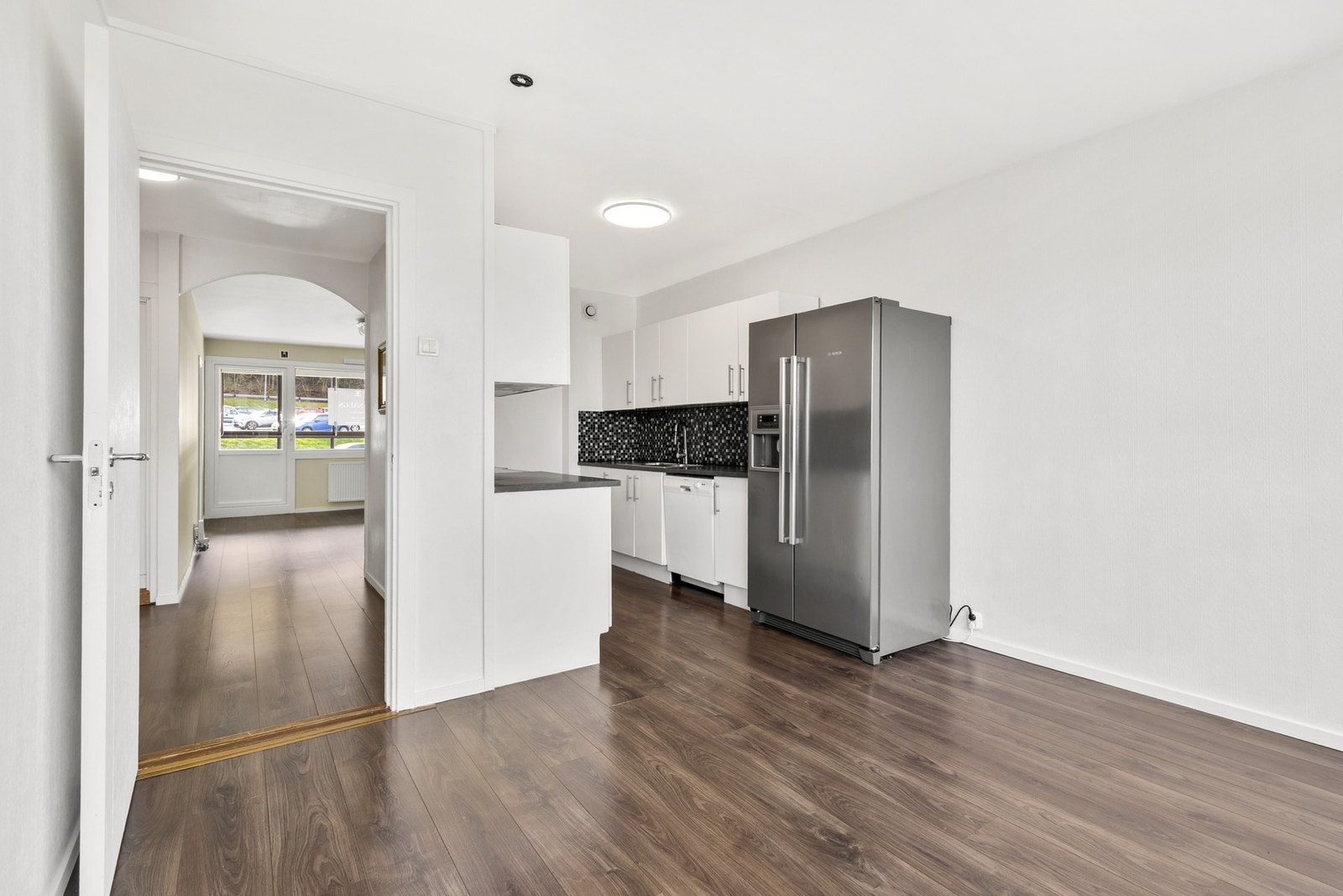 Romslig kjøkken med laminat på gulv og tapetserte vegger Galleribilde