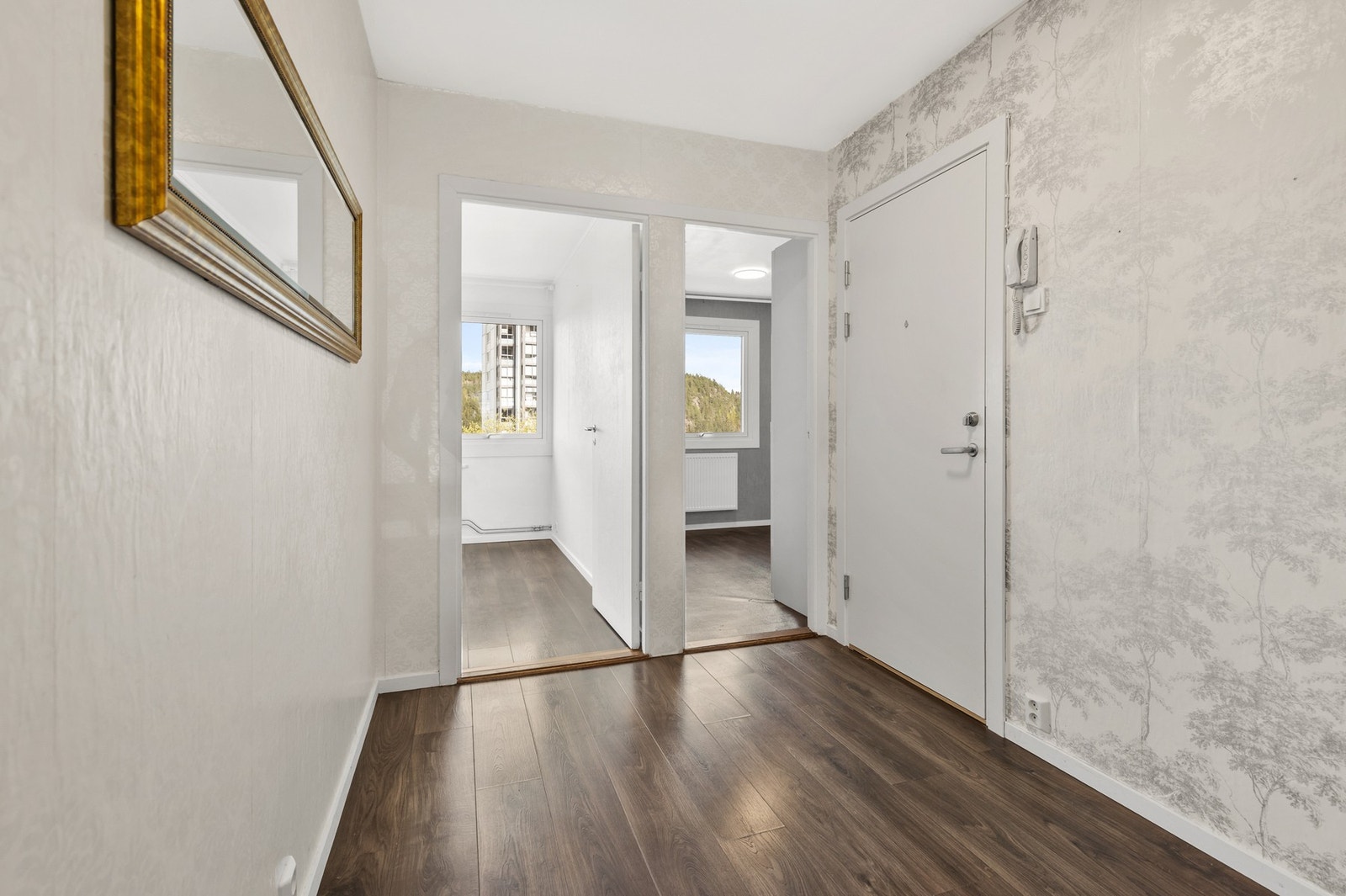 Velkommen inn! Lys entre med laminat på gulv og tapet på vegger Det er montert callingsystem ved inngangsdør Galleribilde