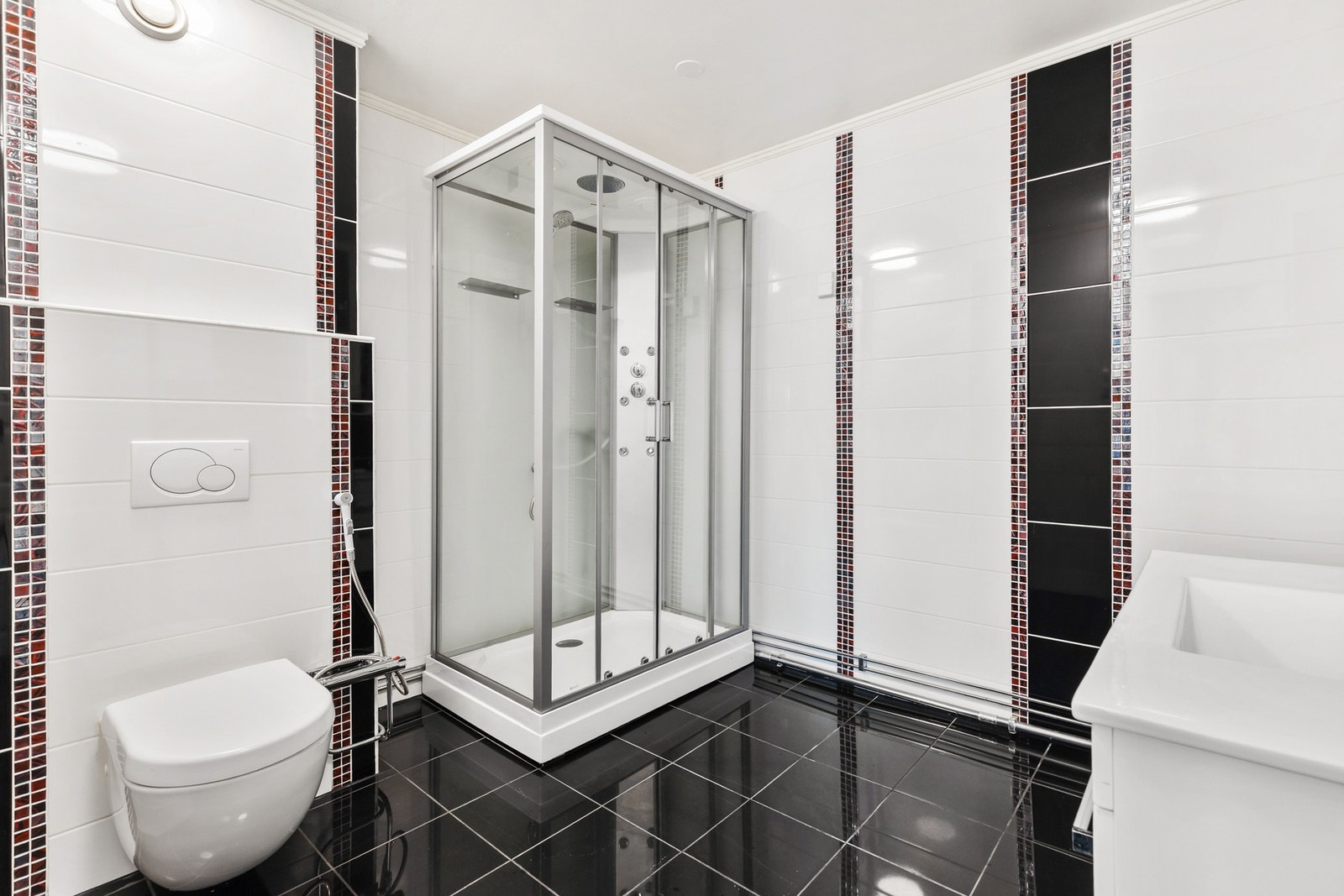 Helfliset bad innredet med stort dusjkabinett og vegghengt toalett Galleribilde