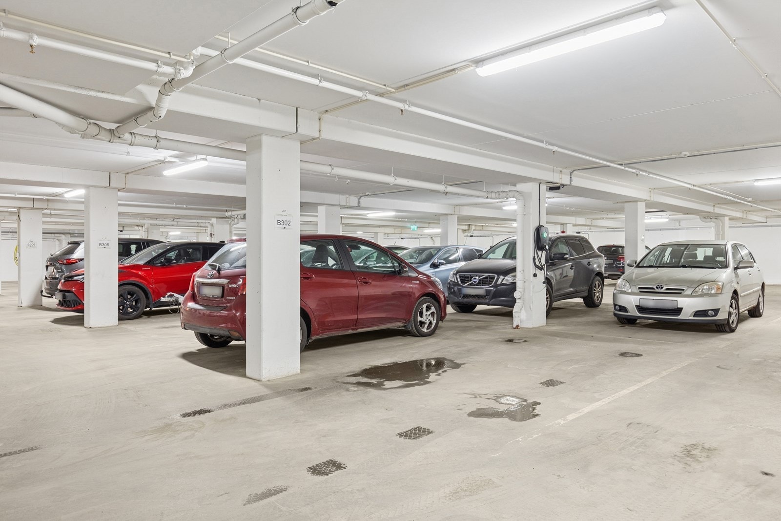 Parkering i garasjekjeller, med elbil-lader. Galleribilde