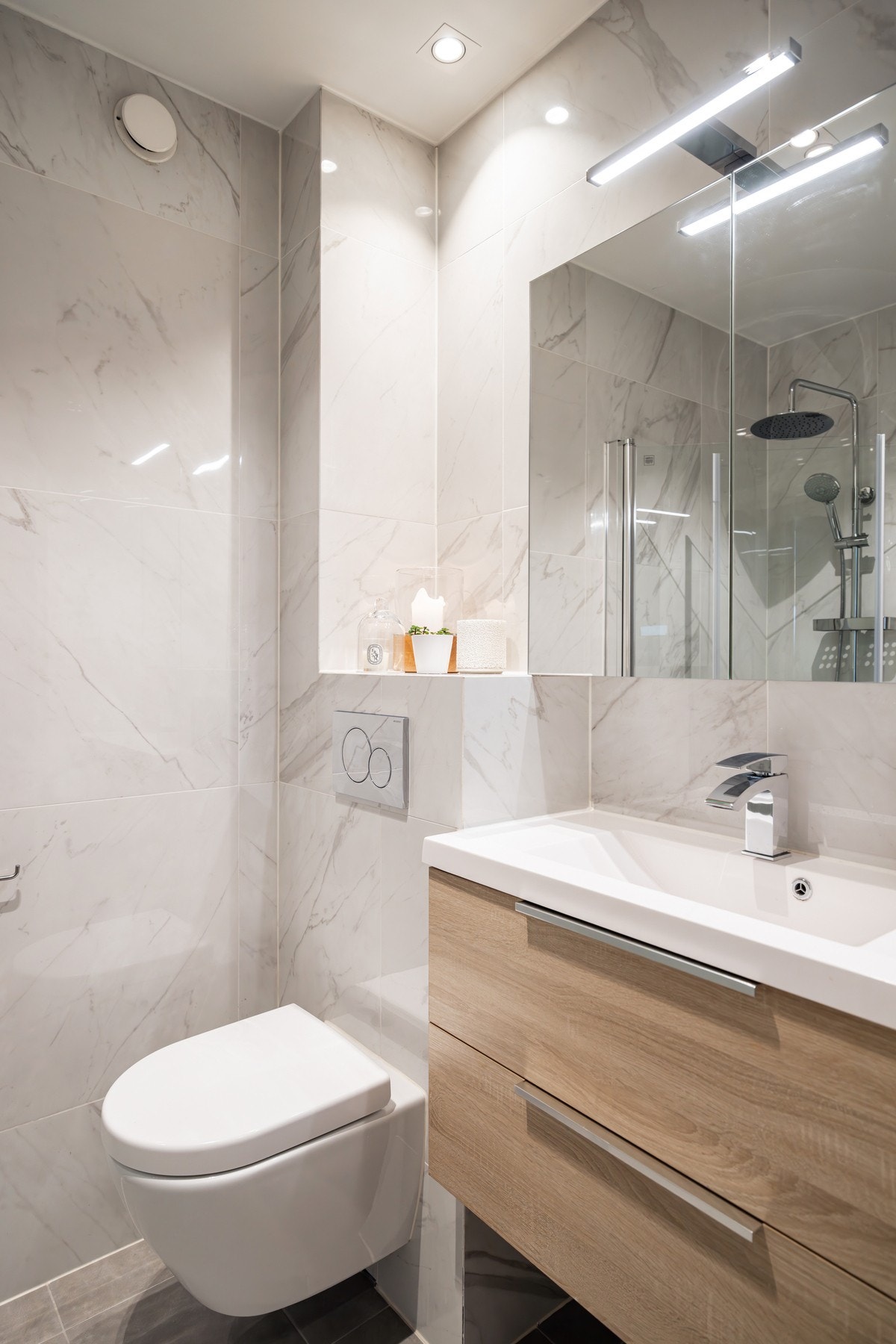 Pen baderomsinnredning med servantskuffer og speilskap med belysning. Galleribilde