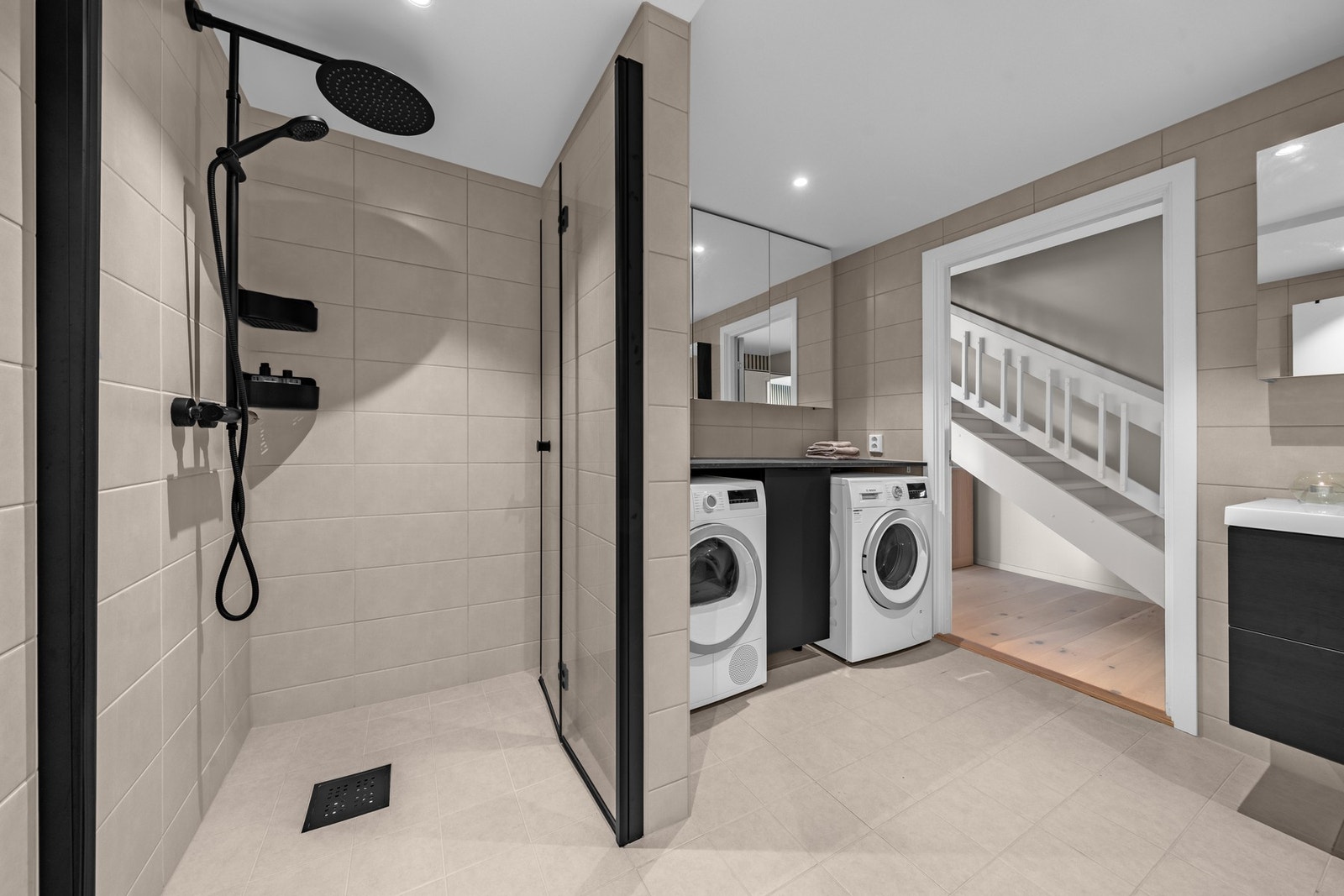 Videre en romslig dusjnisje bak glassdør. Galleribilde