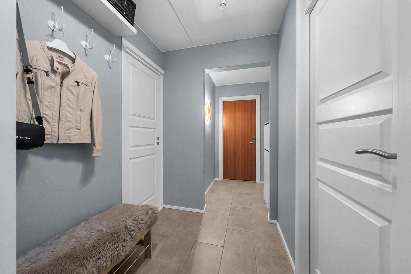 Det er åpen garderobeløsning med plass til å henge fra seg yttertøy og sette fra seg skoene. Det er i tillegg god plass i hendig bod med hyller som har adgang fra entreen via skyvedør! Galleribilde