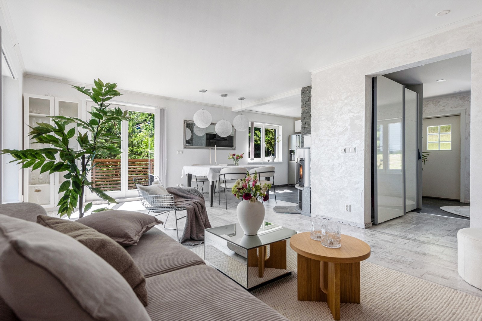 Et stort vindu og en tofløyet dør fyller rommet med naturlig lys og gir lett tilgang til den solrike hjørneterrassen utenfor. Galleribilde