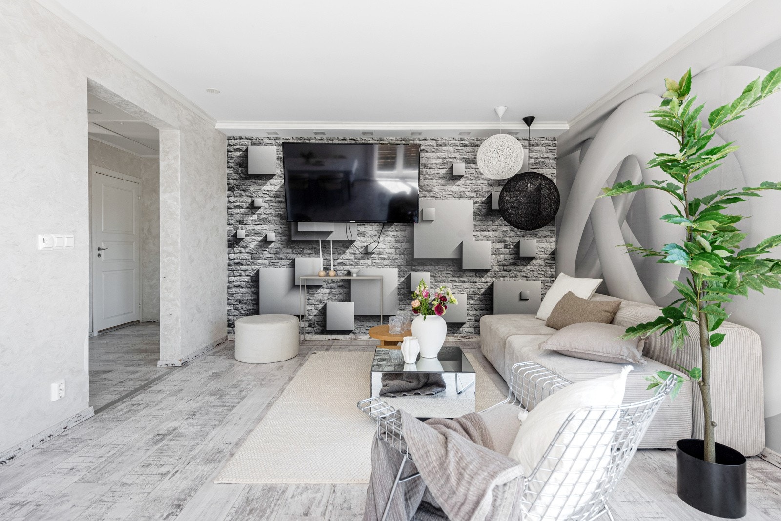 Stuen har et lekent uttrykk med 3D-tapet og lys tapet til hvitmalte vegger for øvrig. På gulvet er det gulvvarme og likt laminatgulv som i entreen Galleribilde