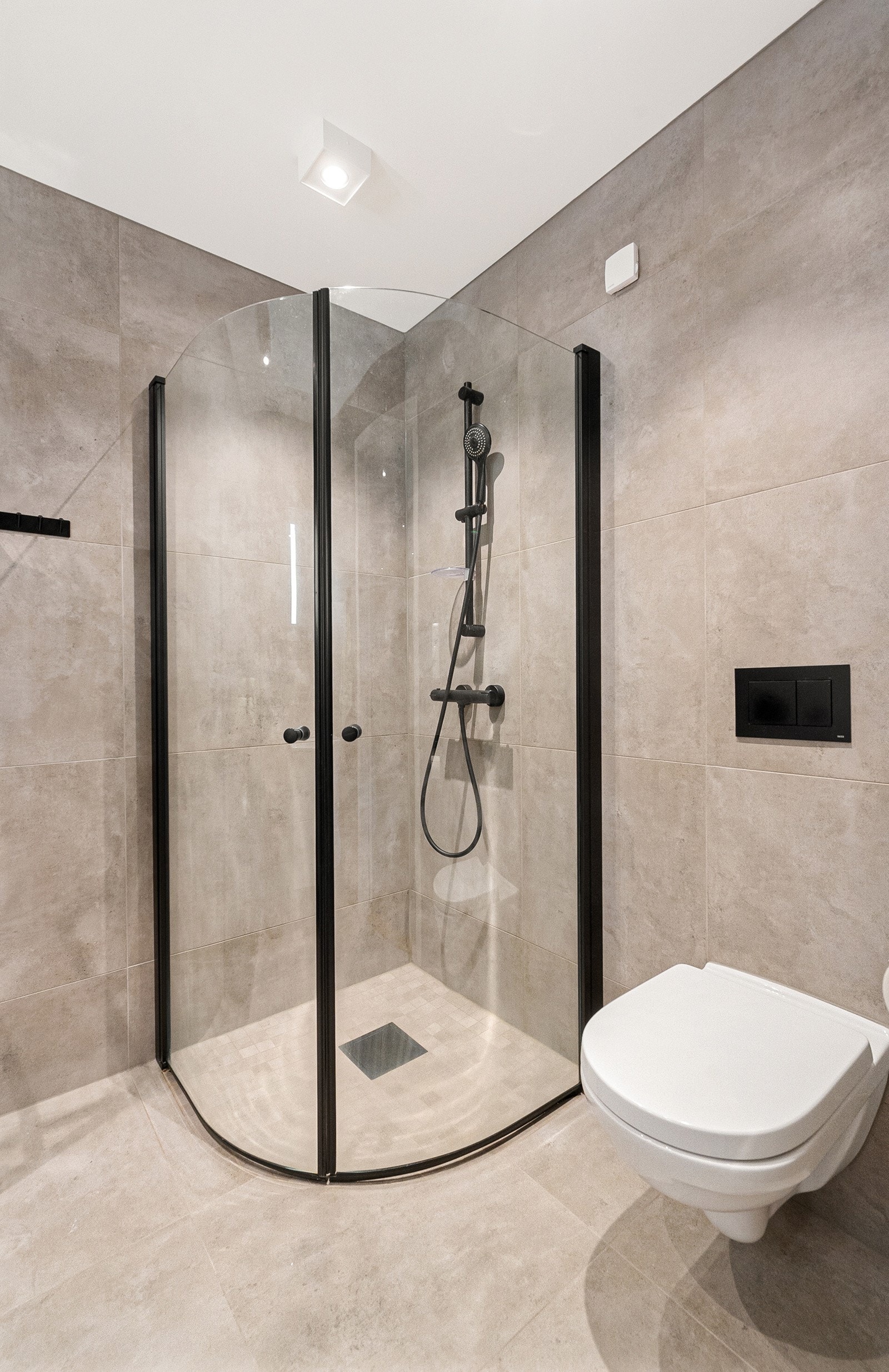 Badet er utstyrt med servant med underskap, dusjvegger og vegghengt wc. Galleribilde