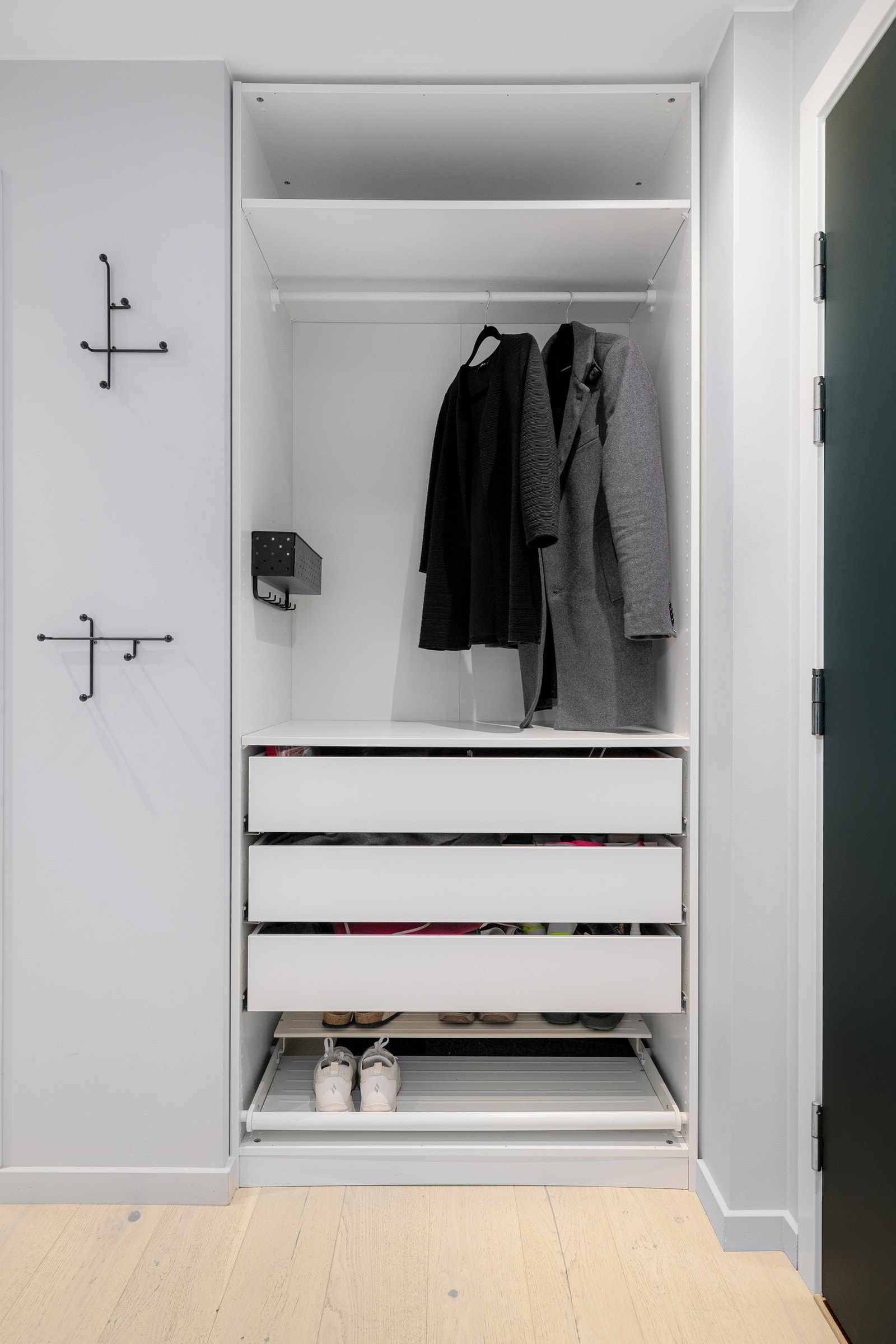 Plassbygd garderobe som gir rikelig med oppbevaringsplass til yttertøy og sko. Galleribilde