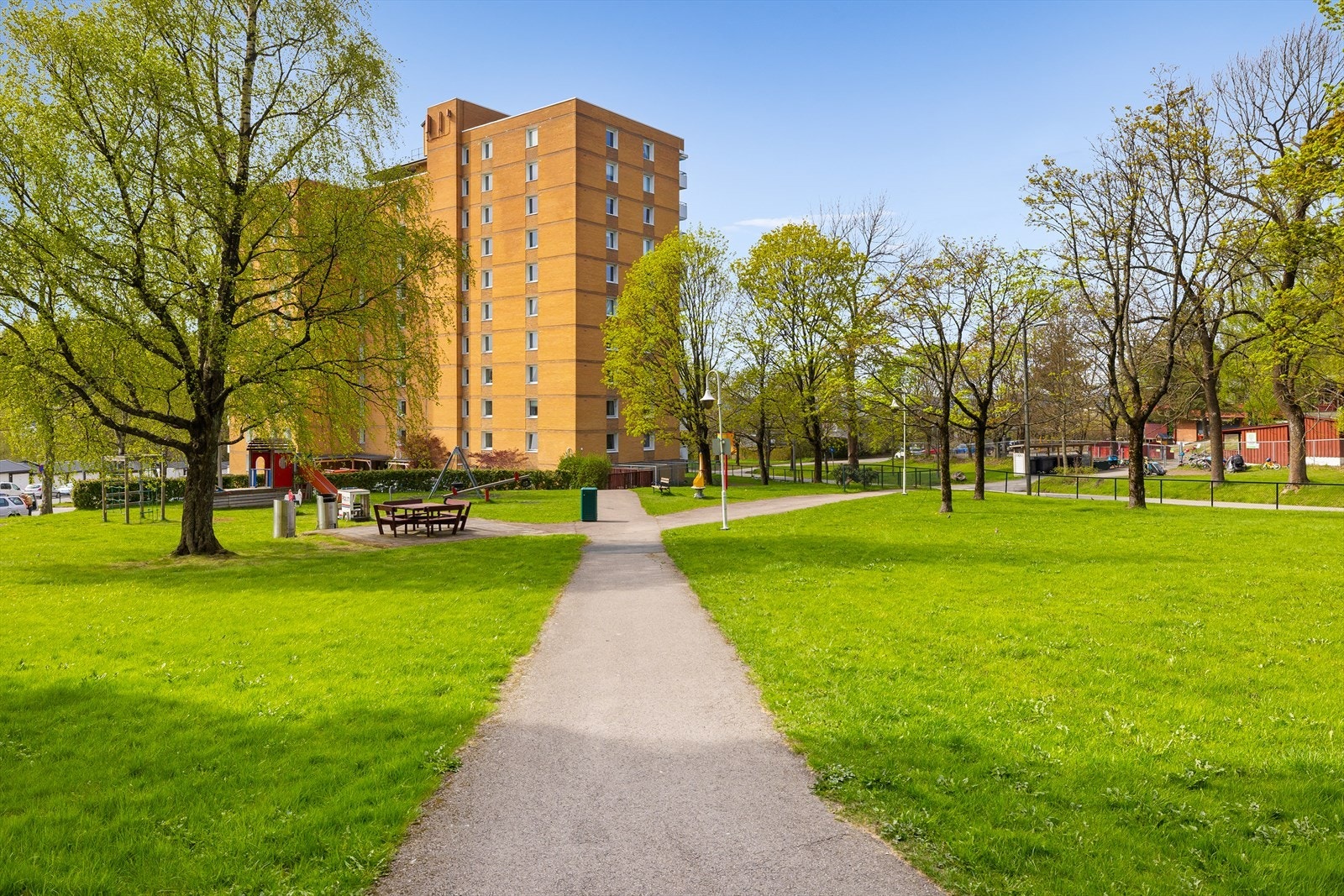 Tomten er pent opparbeidet med internveier, plen og beplanting. Galleribilde