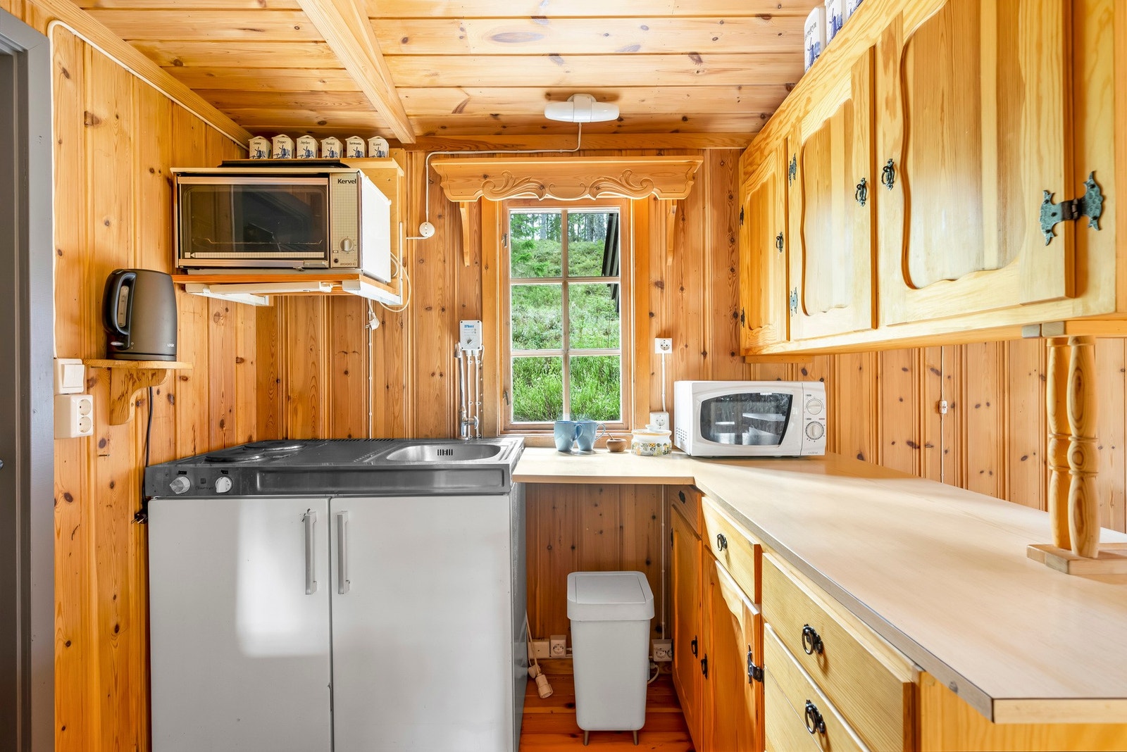 Solid kjøkkeninnredning med laminert benkeplate og nedfelt oppvaskkum. Galleribilde