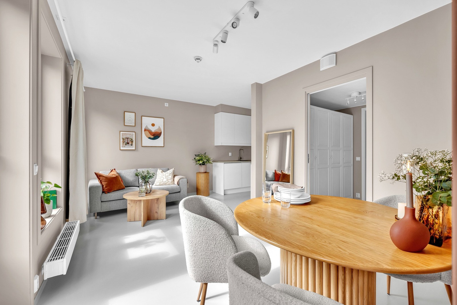 Stuen har åpen løsning til kjøkkenet og er malt i samme delikate farge som i gangen, gulvbordene er malt lyse. Galleribilde