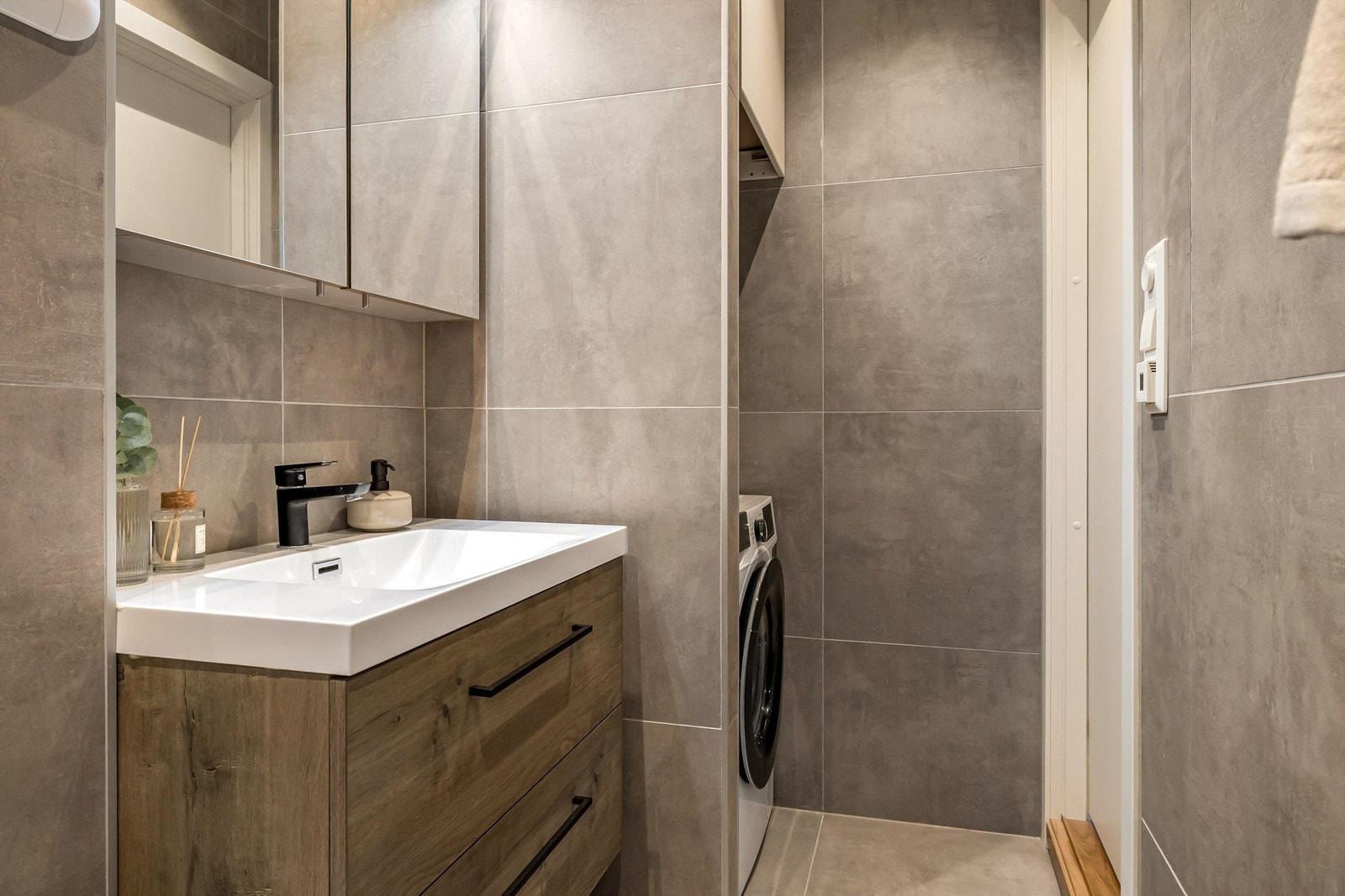 Moderne og flott bad/vaskerom med varme i gulvet. Det har en innholdsrik innredning med god oppbevaringsplass og lekkert overskap. Galleribilde