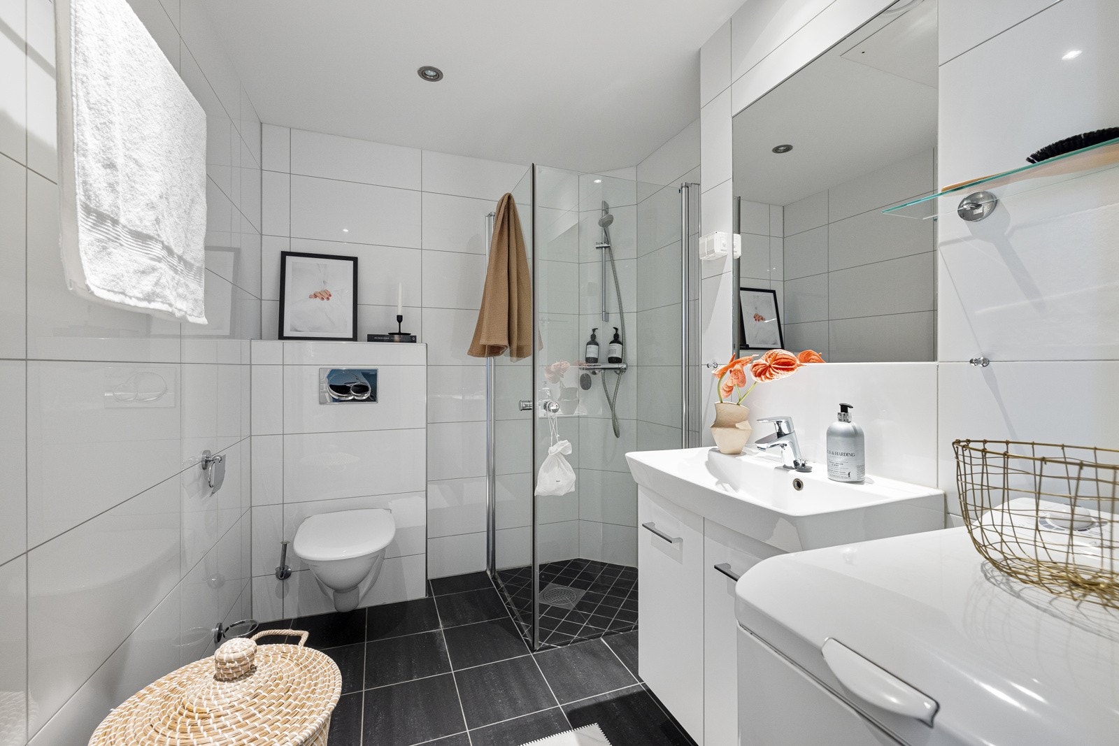 Det er utstyrt med toalett, dusjhjørne med glassdører, samt et praktisk servantskap med hvit keramikkservant og ettgreps blandebatteri fra Hans Grohe. Galleribilde