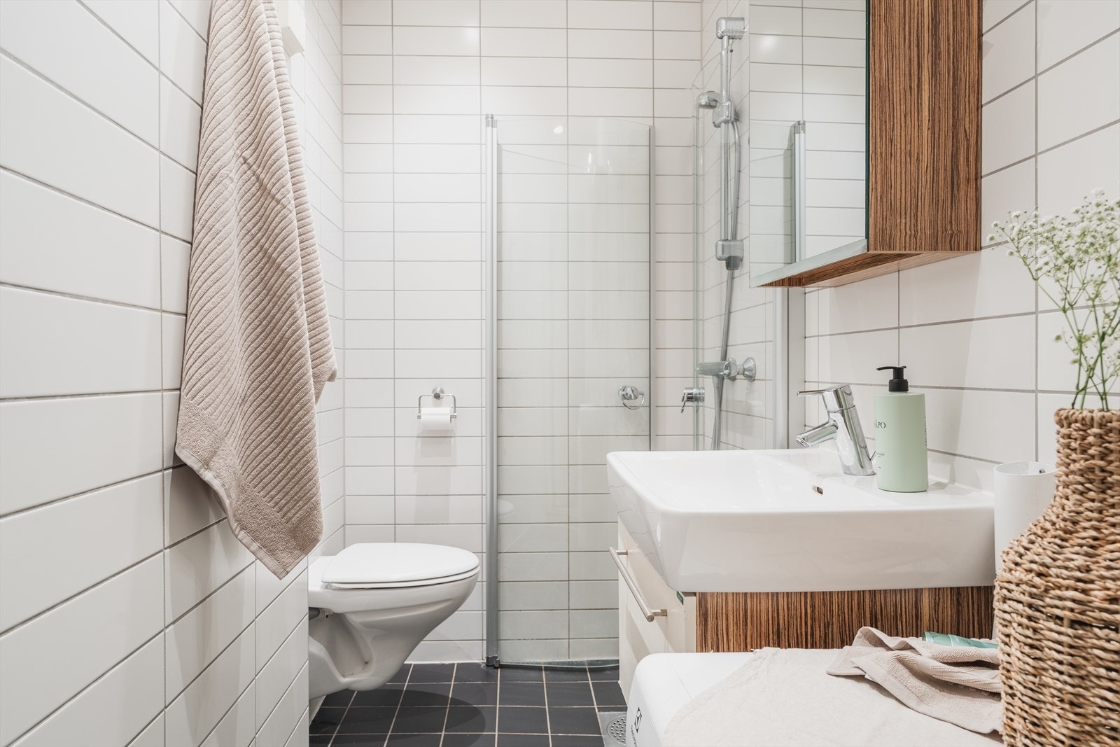 Delikat og helfliset baderom med varmekabler i gulv og opplegg for vaskemaskin Galleribilde