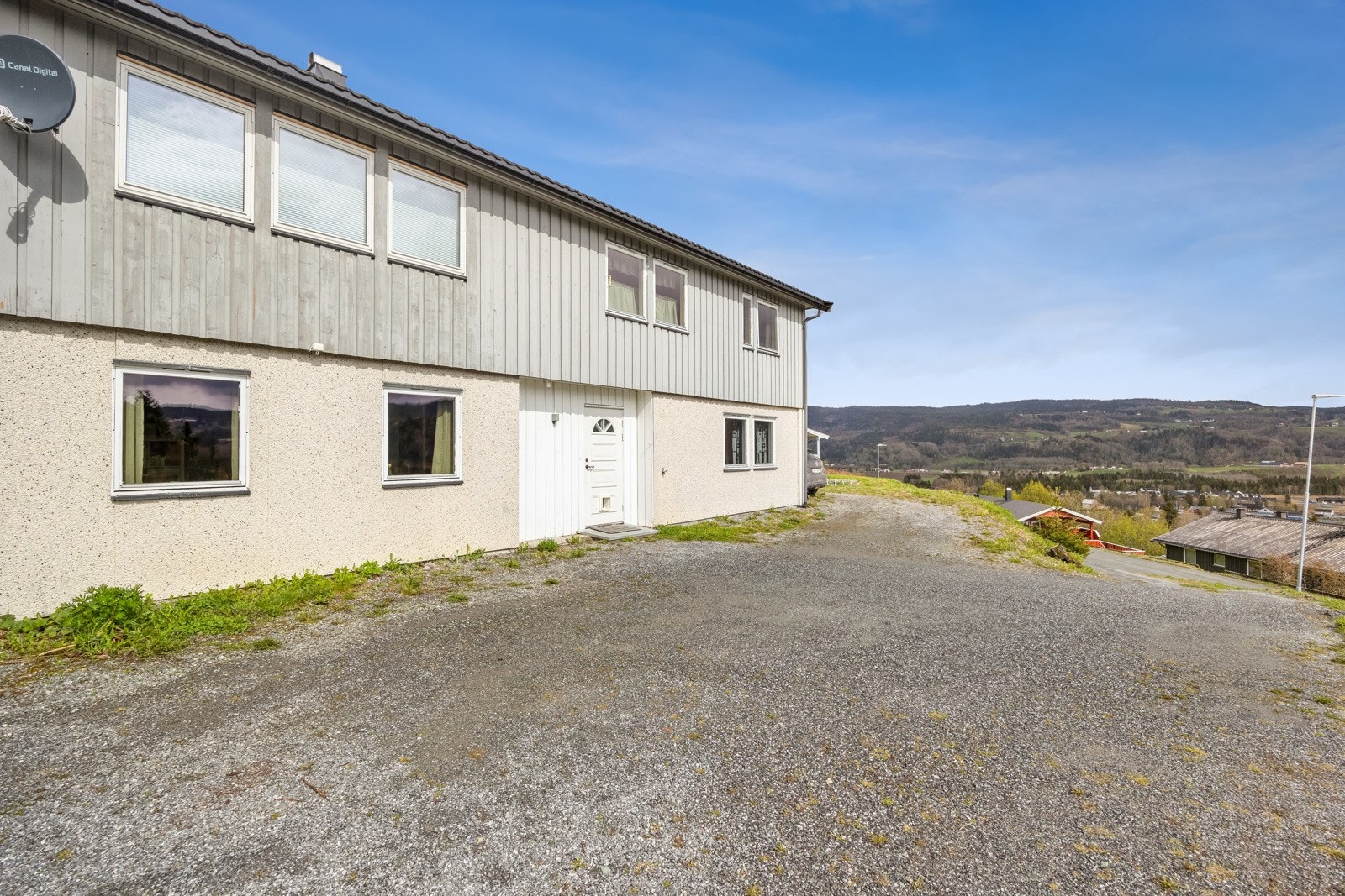 Tomt opparbeidet med gruslagte veier, plenareal og biloppstillingsplass. Galleribilde