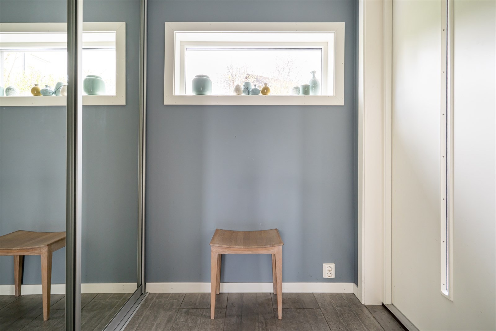 Et lyst og innbydende vindfang med varmekabler. Her er det god plass til yttertøy og sko i en praktisk skyvedørsgarderobe med speilfronter. Galleribilde