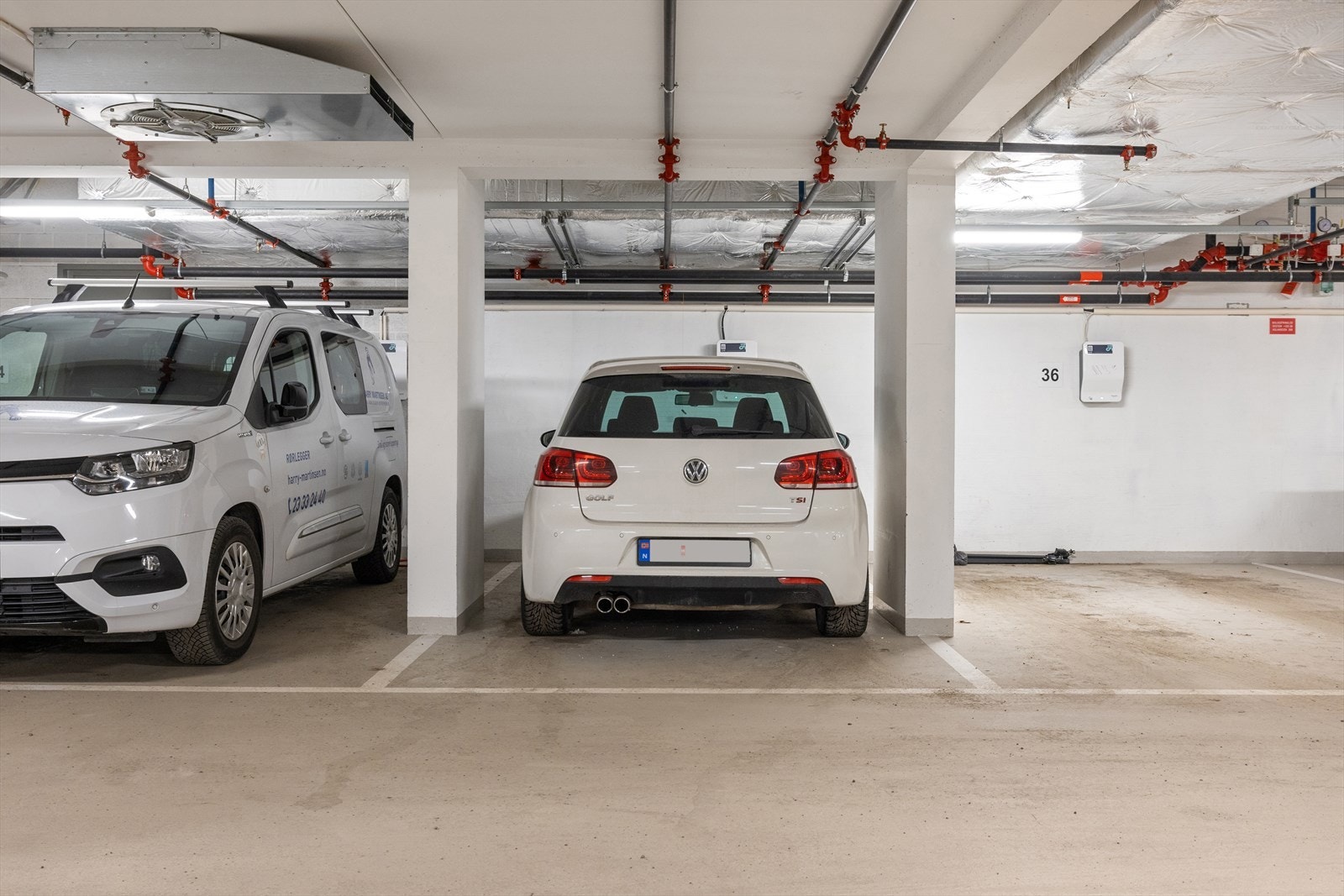 Det medfølger to garasjeplasser med elbillader i et lukket og oppvarmet garasjeanlegg, merket med nr. 89 (bred plass til større bil) og 35 (smalere plass til mindre bil). Galleribilde
