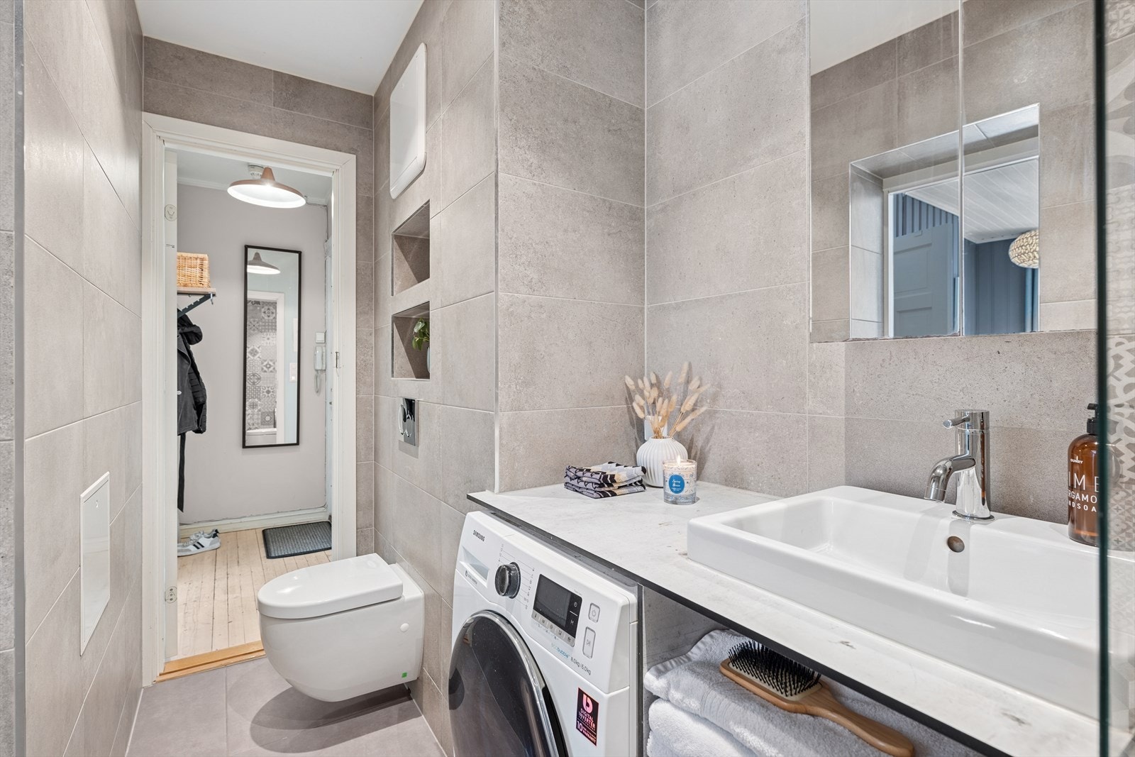 Boligen er innredet med et lekkert bad fra 2018 med vegghengt klosett, opplegg for vaskemaskin samt stor benkeplate med servant. Galleribilde