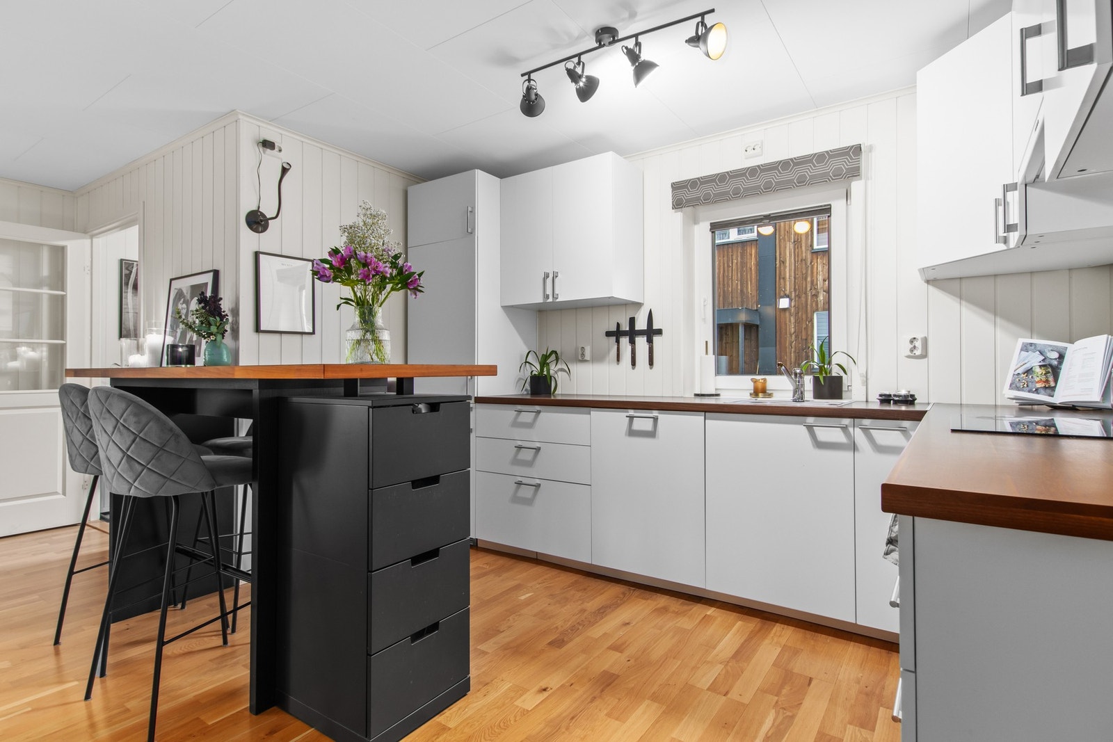 Kjøkkenøya er med på å skille stua fra kjøkkenet, samtidig som den er bygd for både oppbevaring og sosiale stunder. Galleribilde
