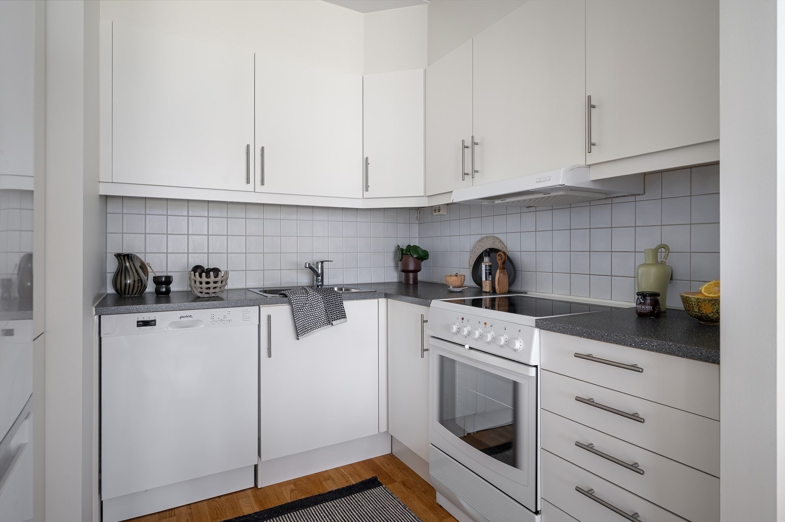 Kjøkkenet er innredet med lyse, slette fronter og en flott benkeplate i mørk kontrast. Galleribilde