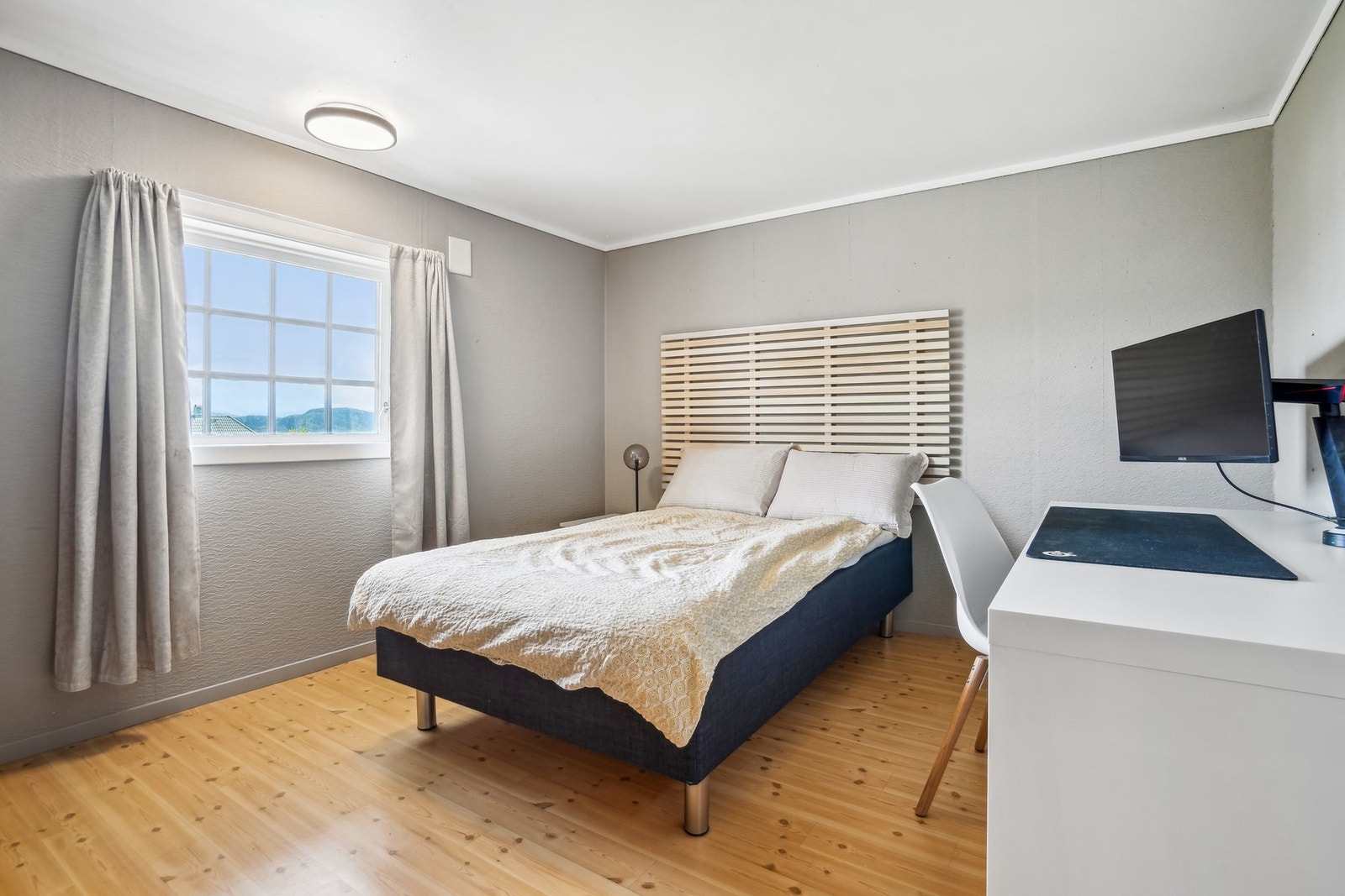 Det første soverommet i underetasjen er av god størrelse, med plass til seng av ønsket størrelse og tilhørende møblement. Legg merke til spileveggen. Galleribilde