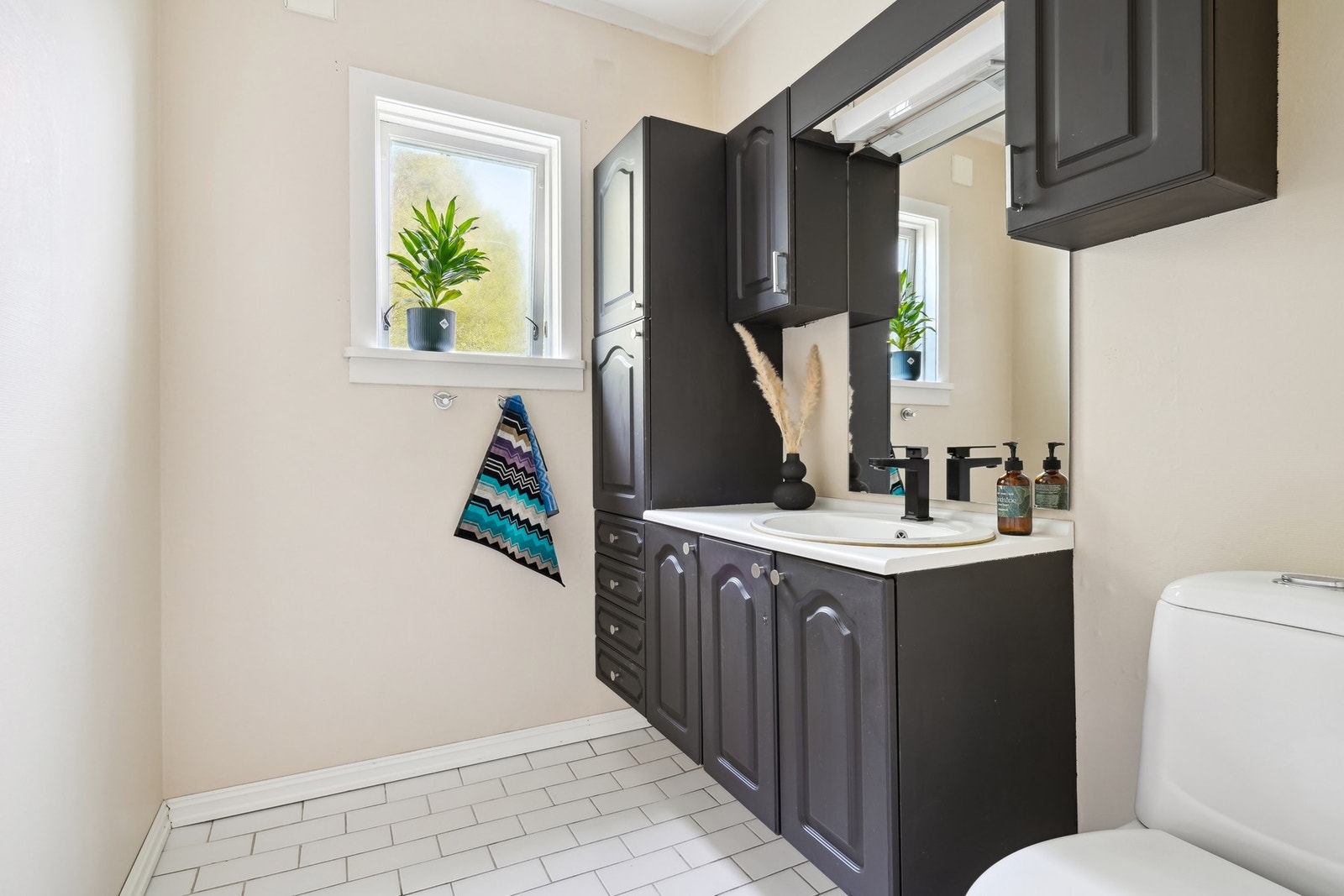 Praktisk toalettrom med romslig baderomsinnredning i hovedplan. Galleribilde