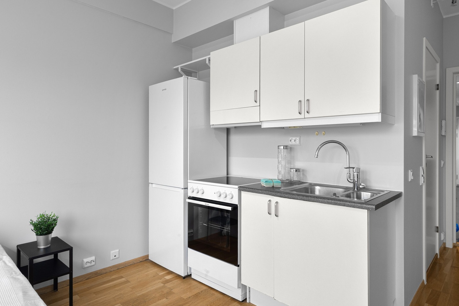 Innredningen har glatte fronter i hvit utførelse kombinert med benkeplate av laminat med nedfelt kum i stål. Galleribilde